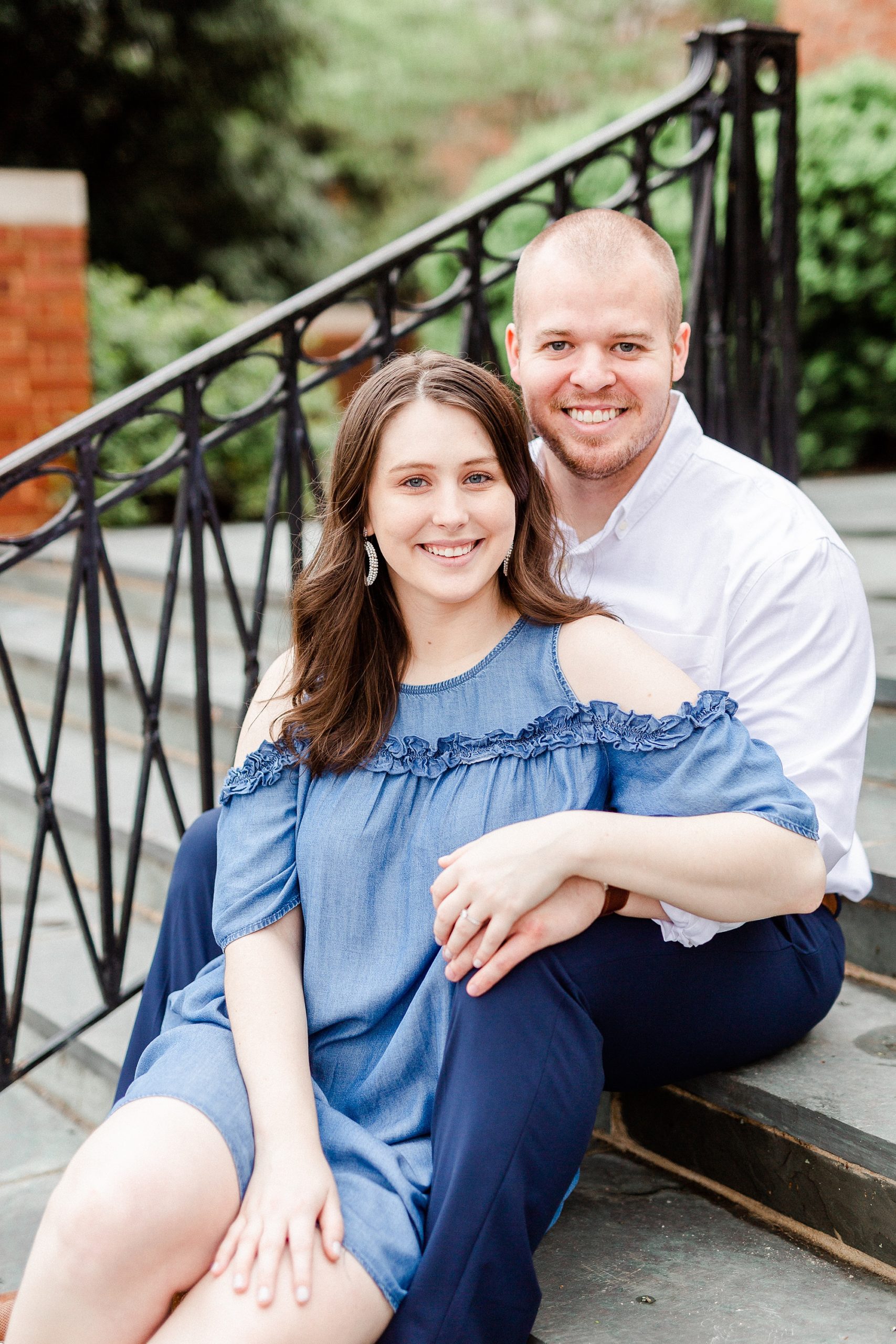 bride and groom sit together on steps of building in Downtown Davidson