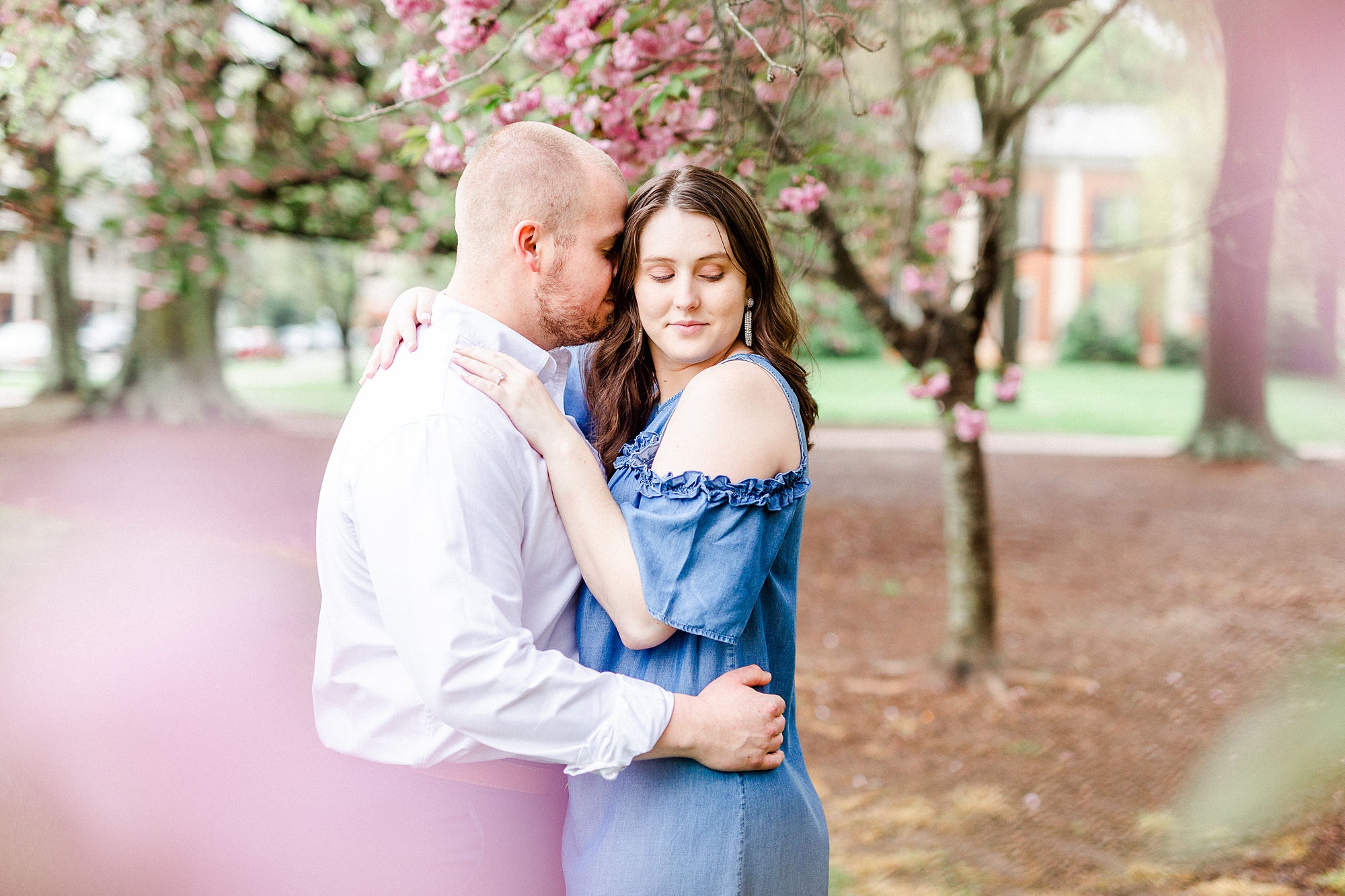 bride and groom pose together in cherry blossom tree
