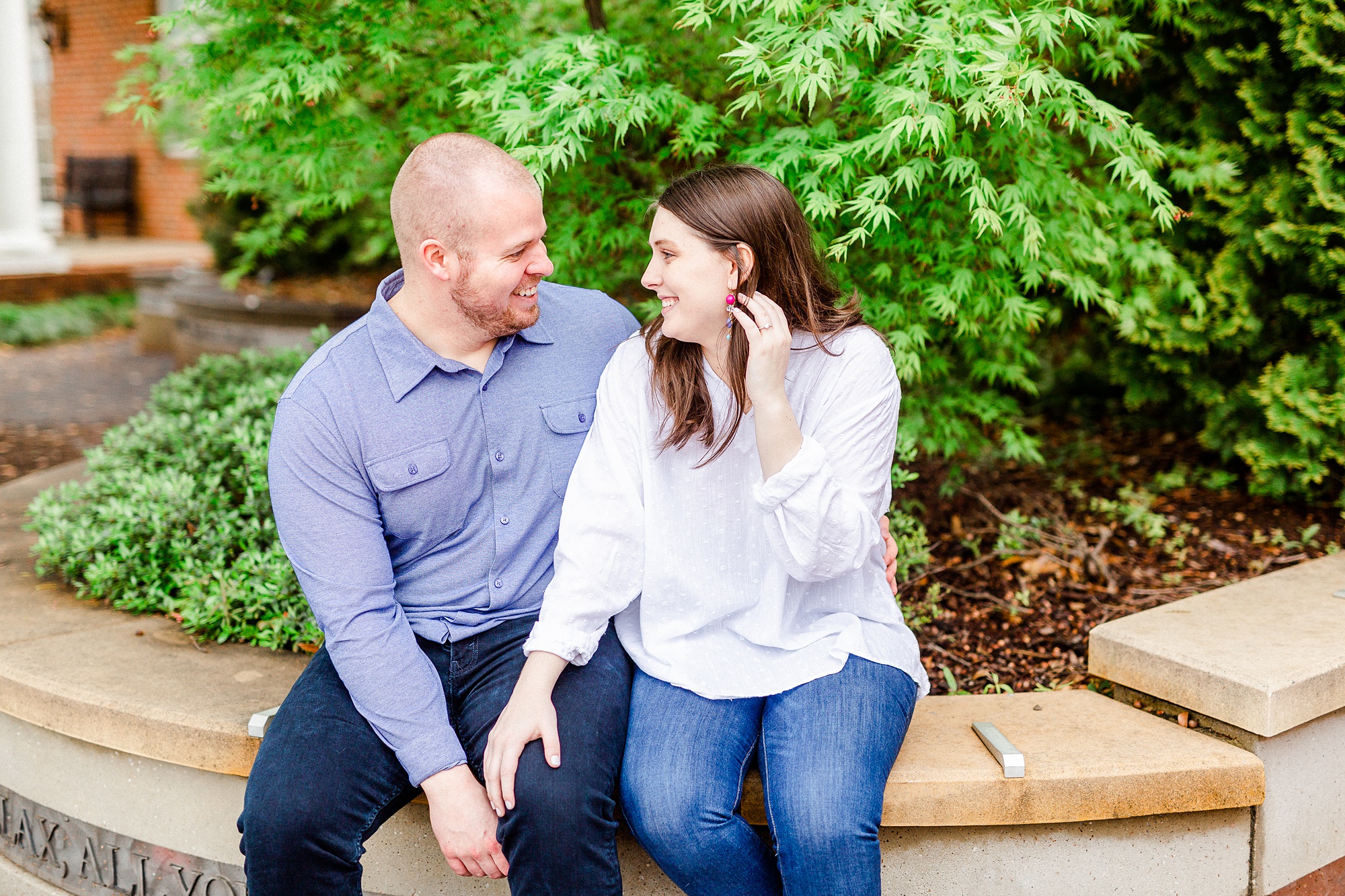 bride and groom laugh sitting by tree in Downtown Davidson
