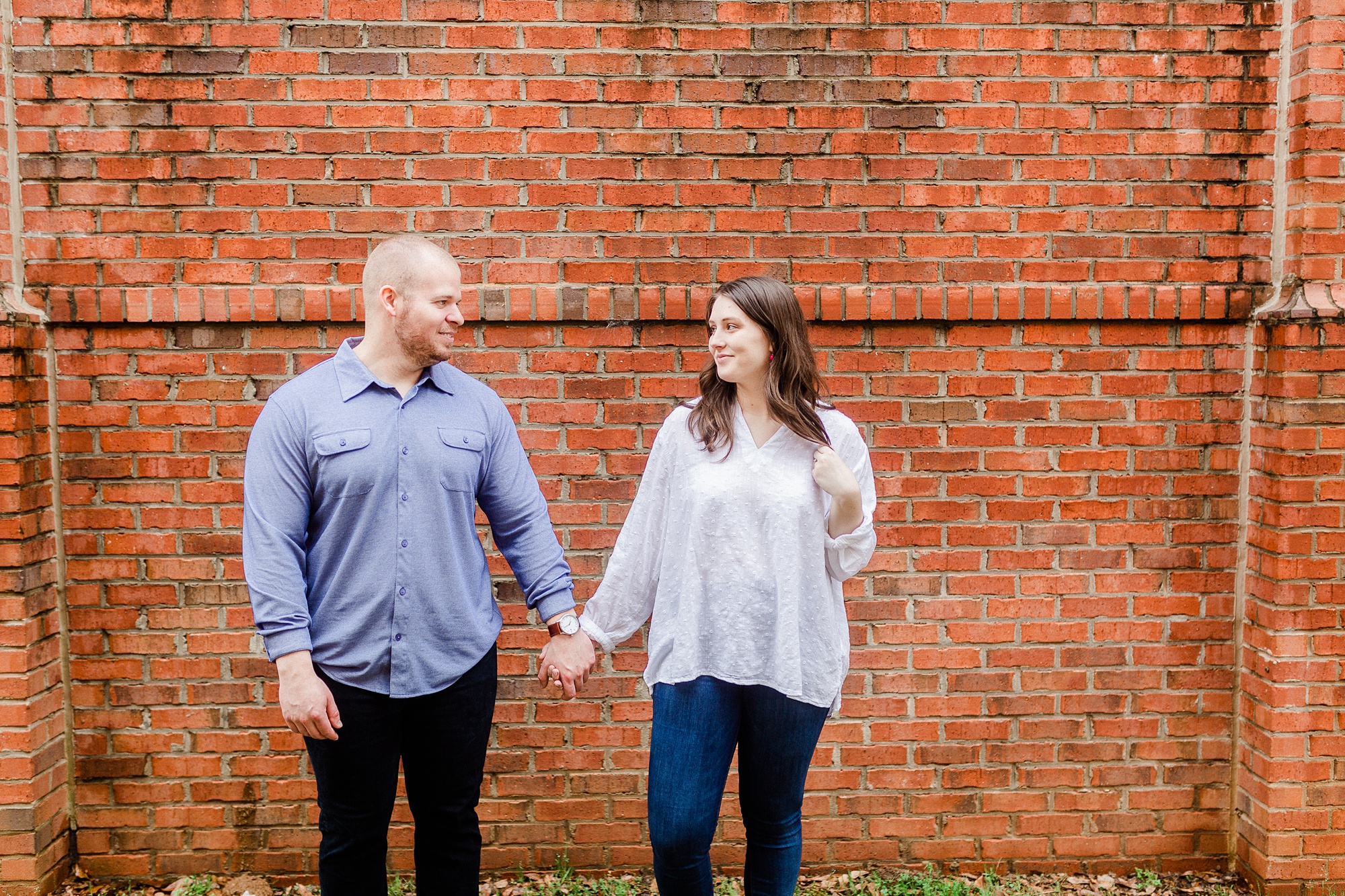 Downtown Davidson NC engagement portraits along brick wall
