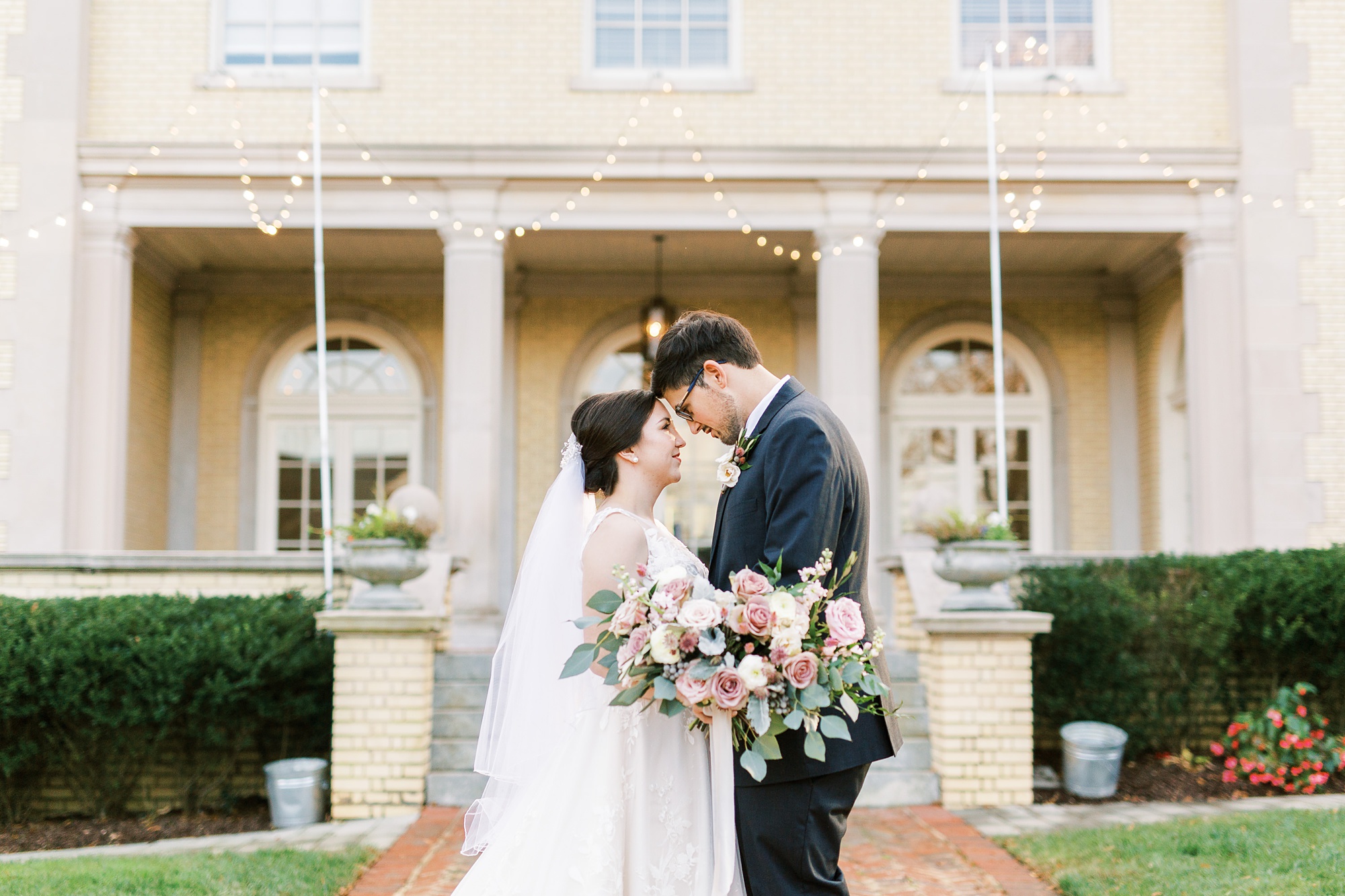 bride and groom stand with foreheads touching in front of Separk Mansion