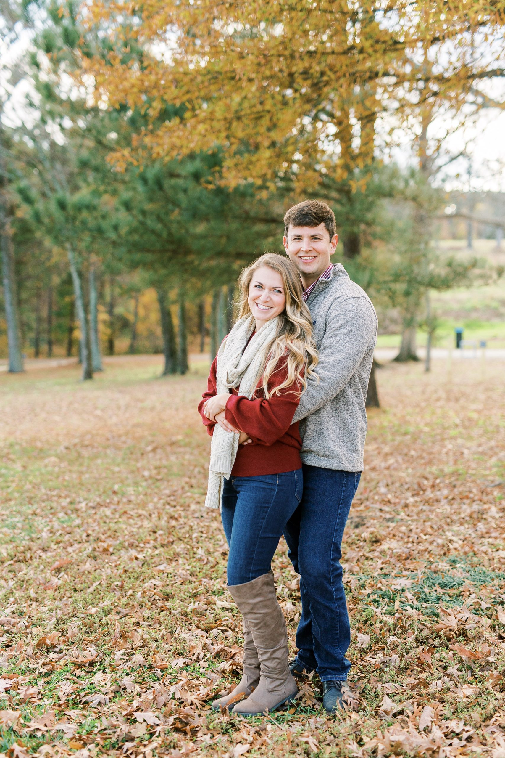 bride and groom stand together in leaves