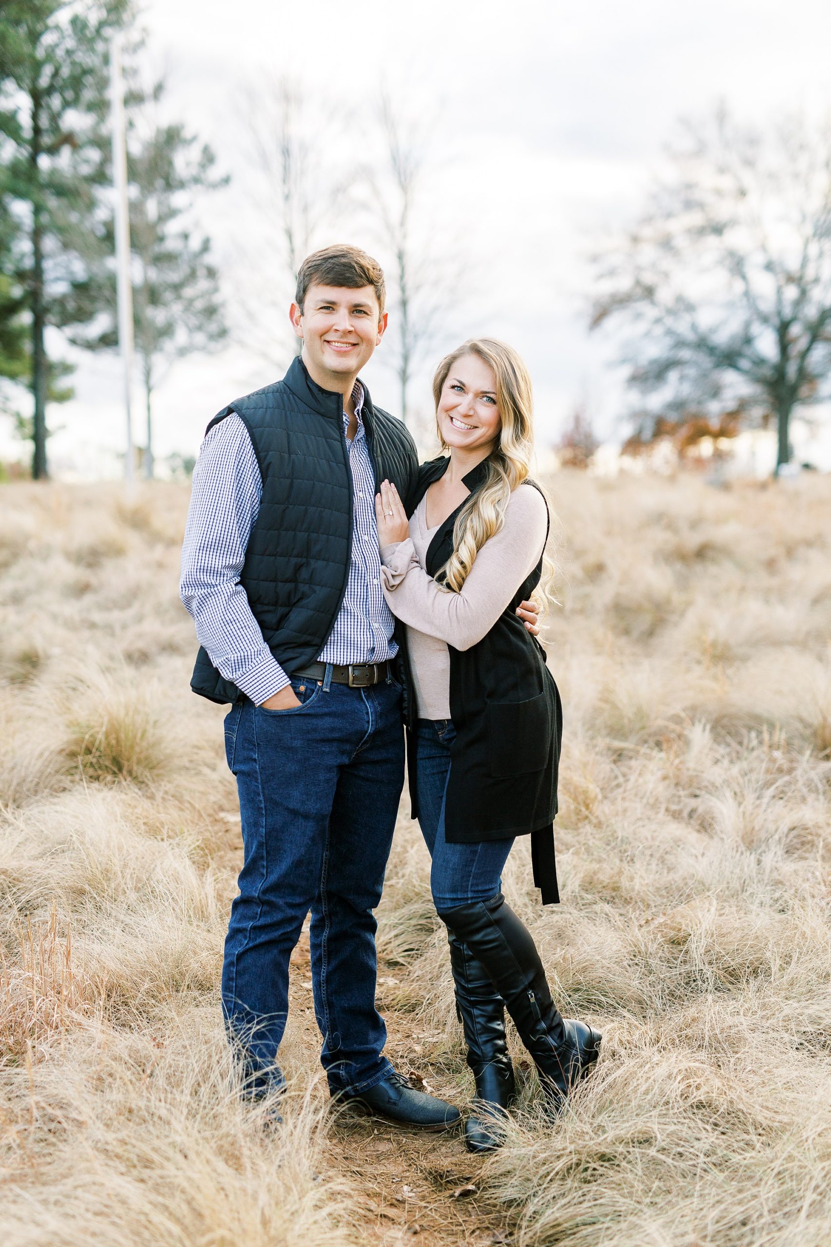 engaged couple poses in field at NC Museum of Art