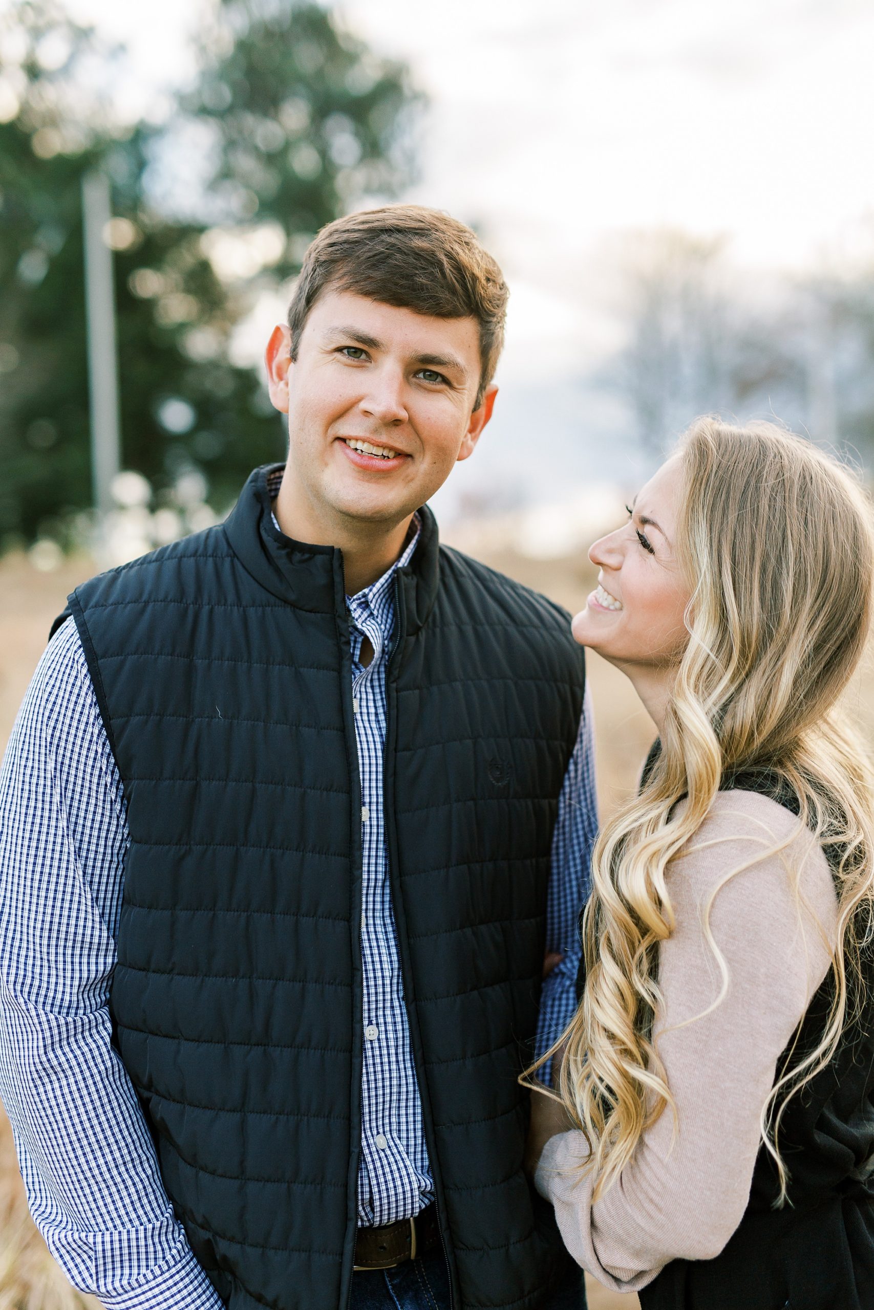 bride looks up at fiance during NC Museum of Art engagement photos