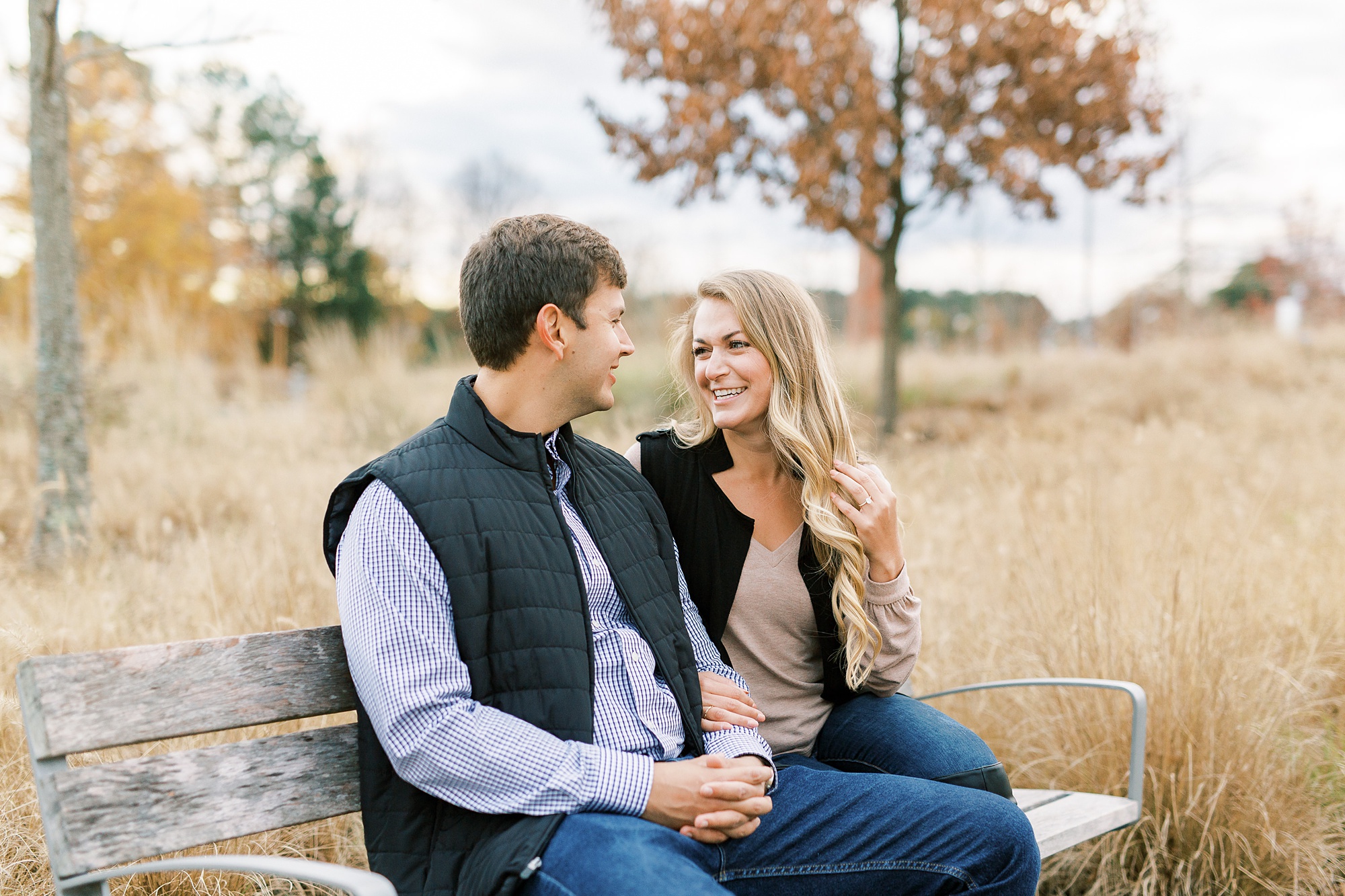 engaged couple sits on bench outside NC Museum of Art
