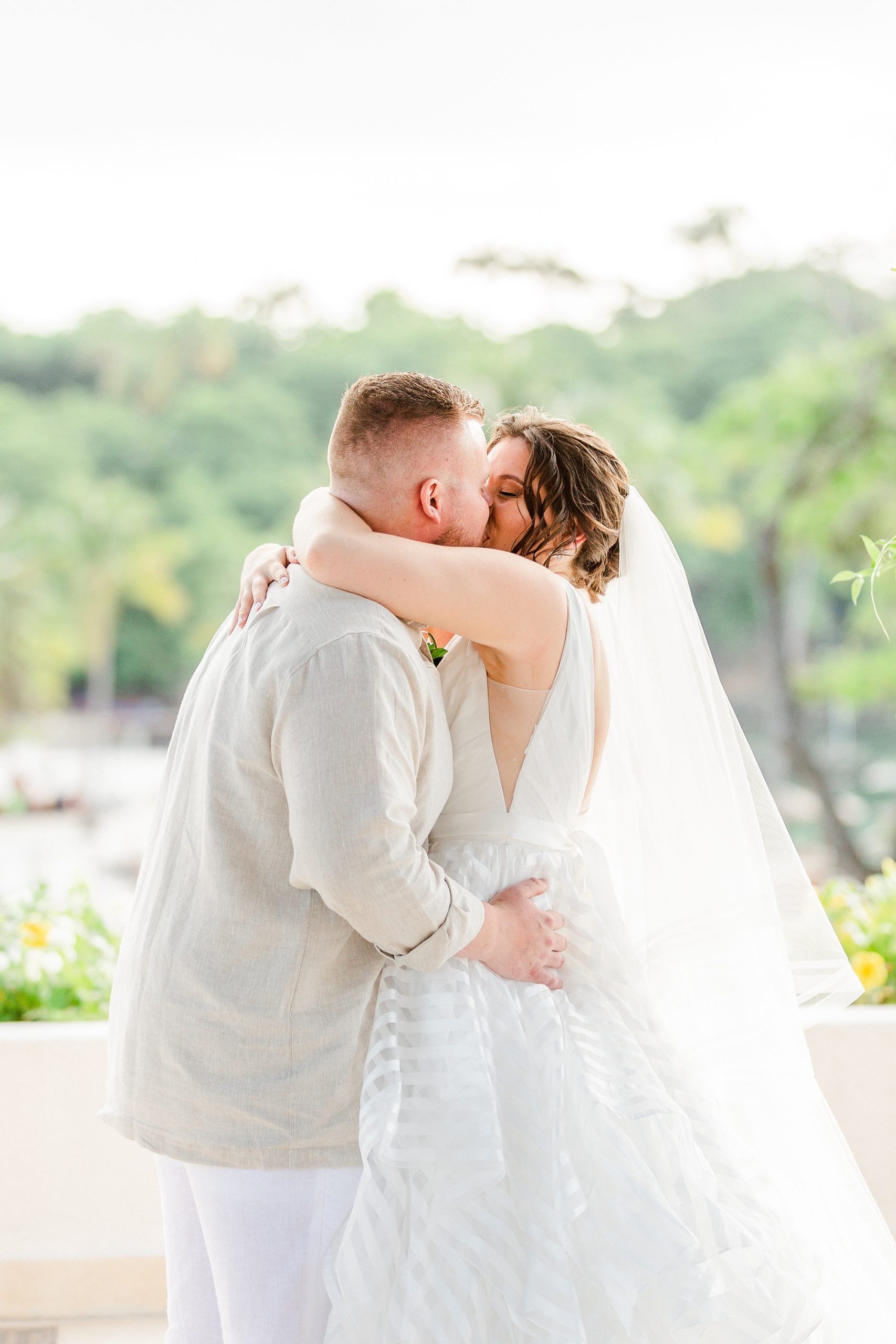 bride and groom kiss during beach wedding ceremony
