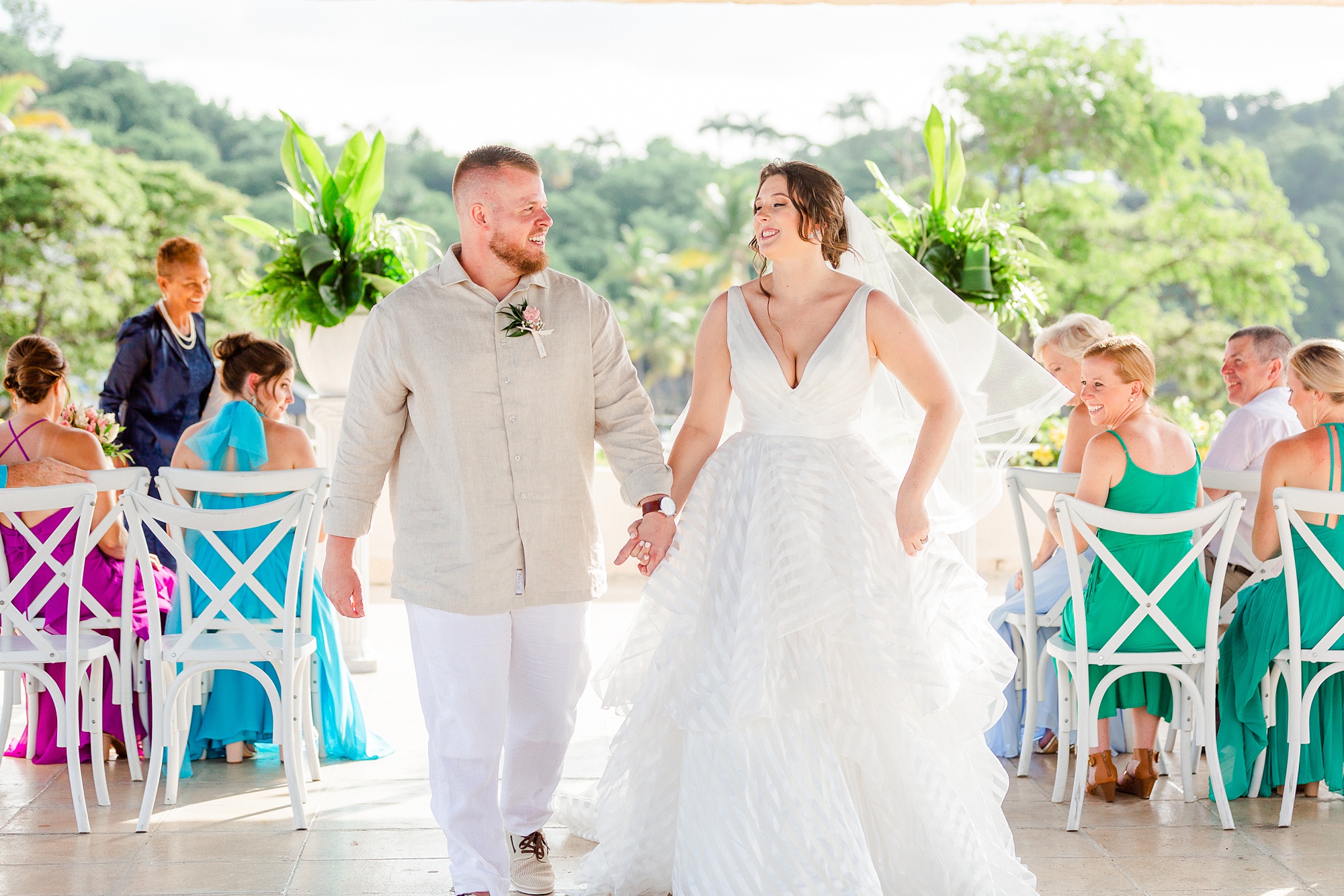 newlyweds laugh walking up aisle after ceremony