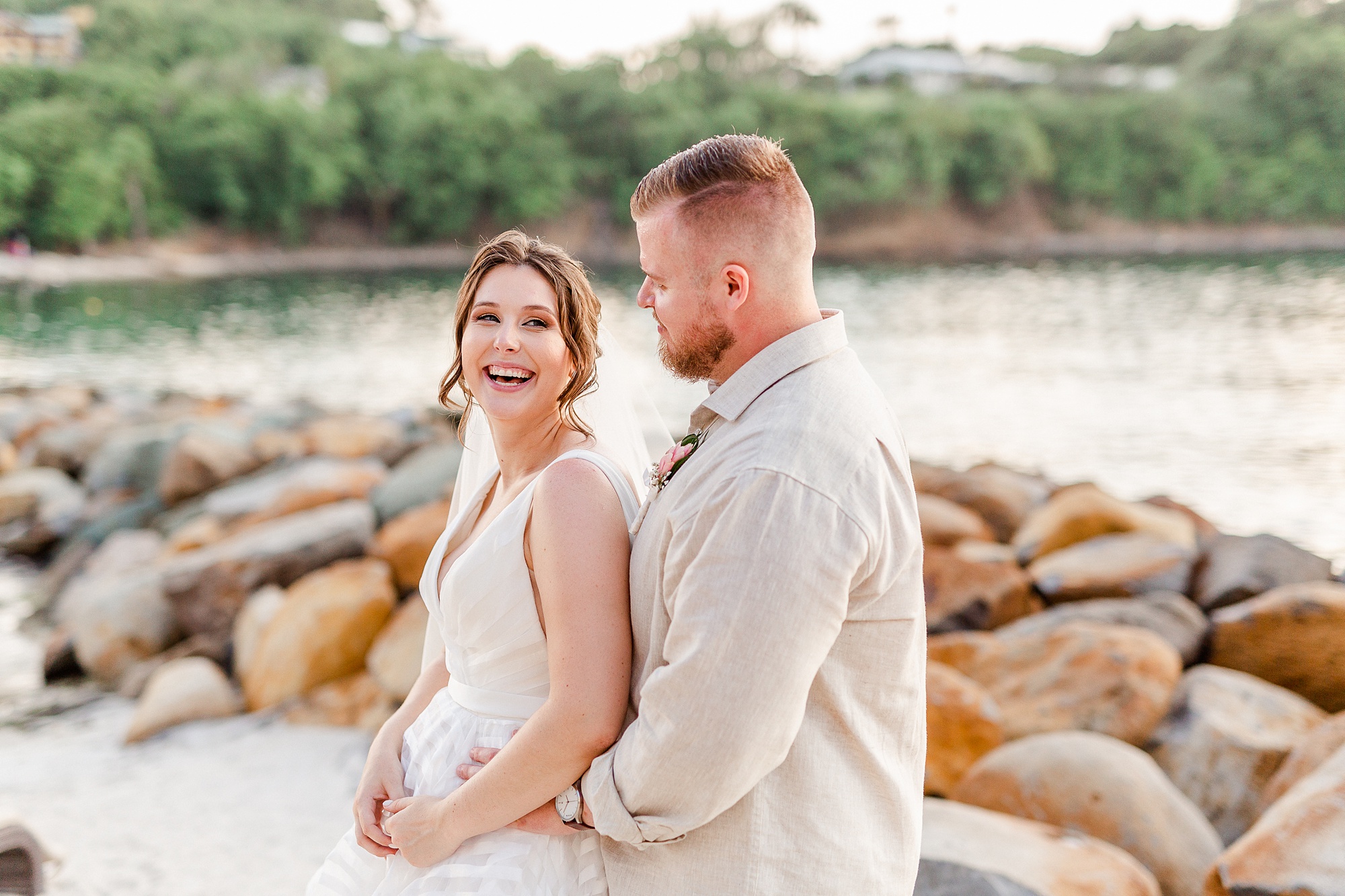 bride and groom laugh along beach in St Lucia