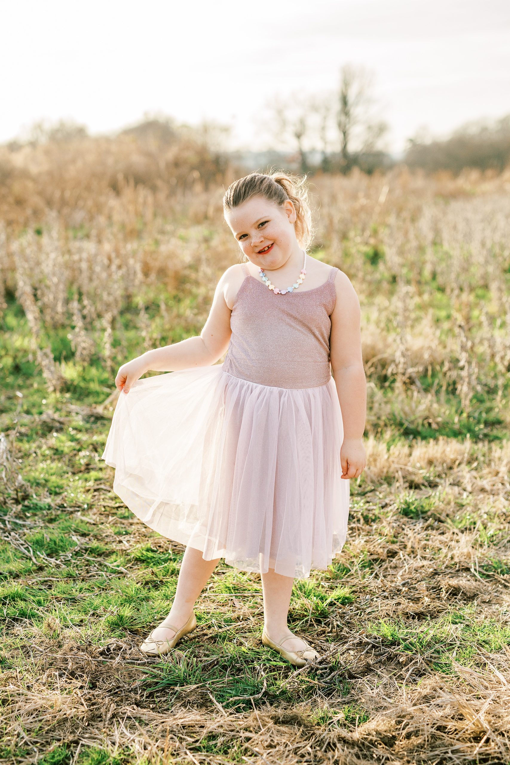 daughter twirls ballet gown during family photos