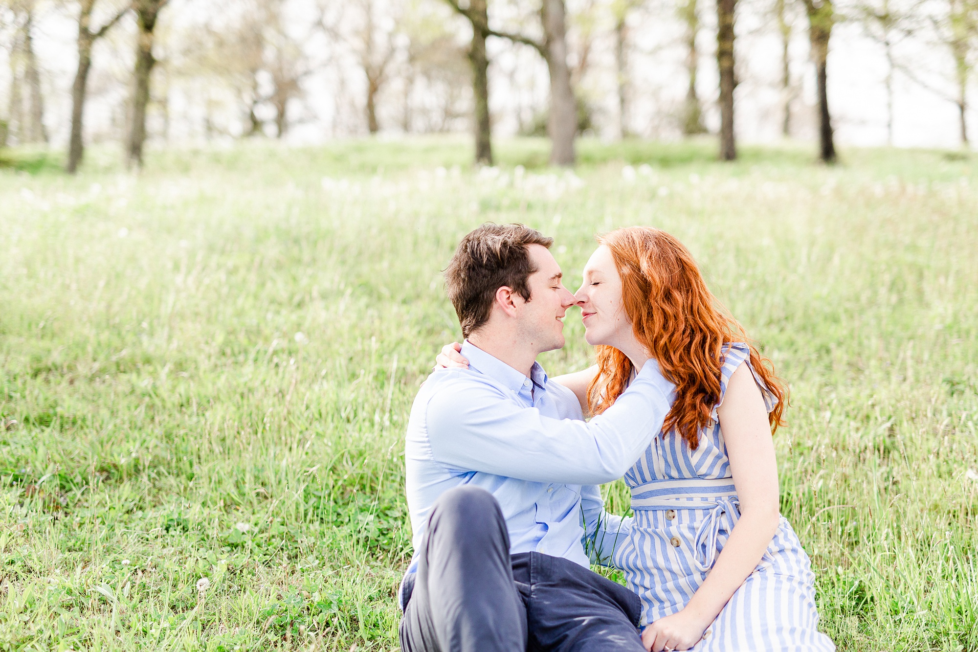 engaged couple sits with noses touching during spring engagement photos