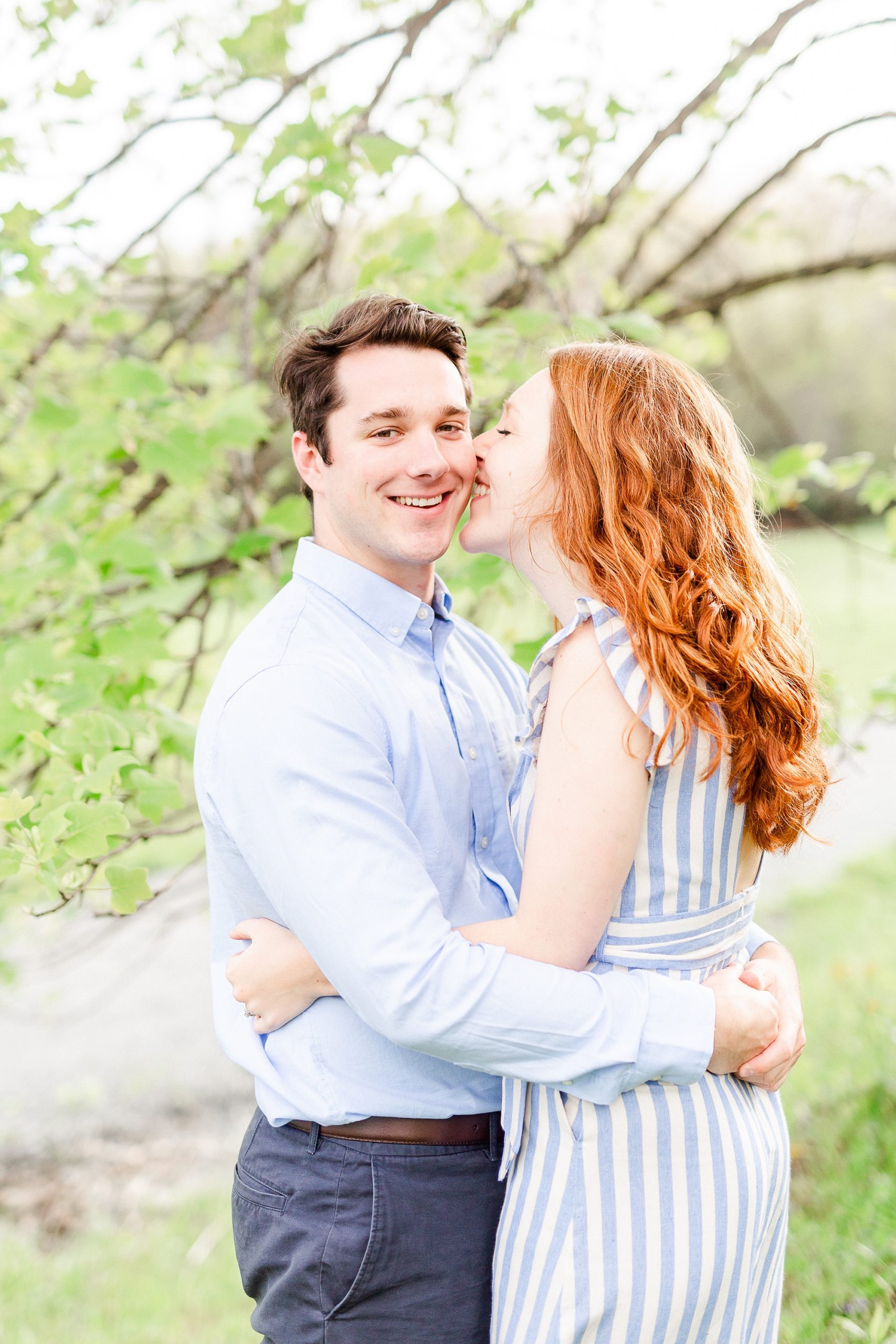 bride kisses groom's cheek during NC engagement photos