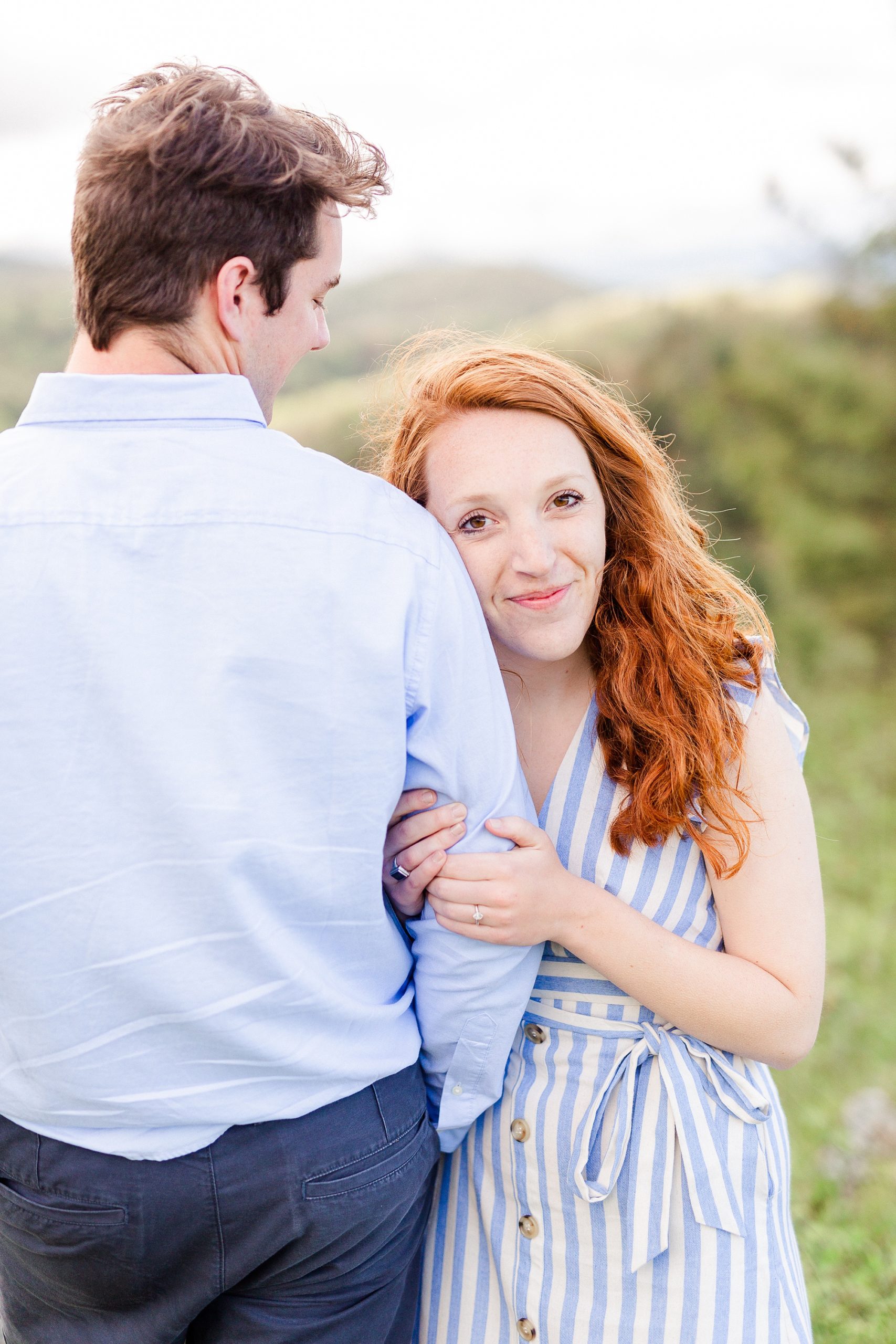 bride leans against groom's shoulder during spring engagement photos