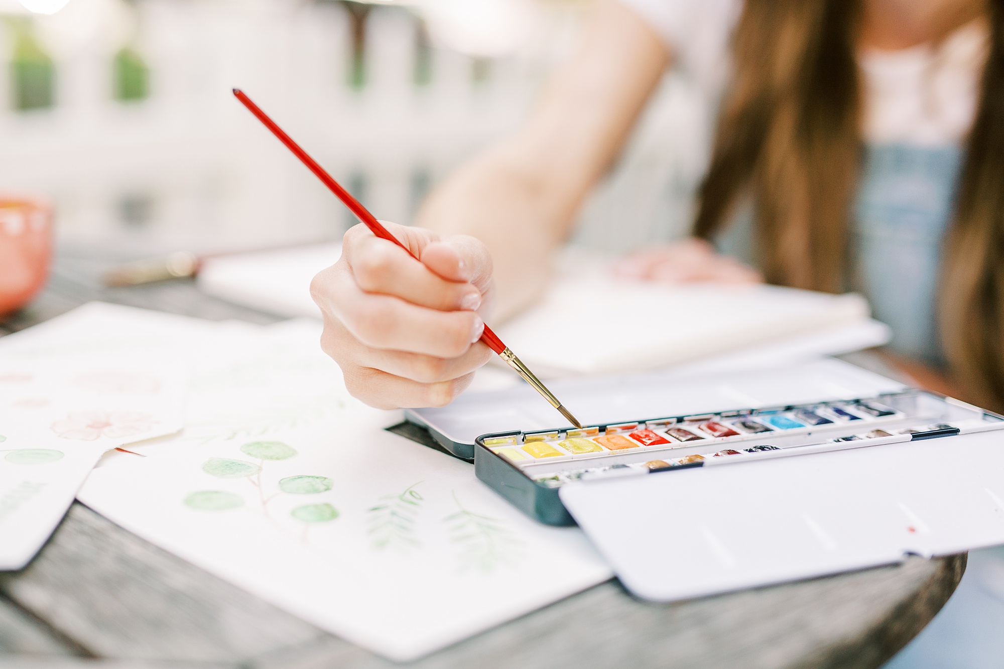artist plays with watercolor paints during branding photos