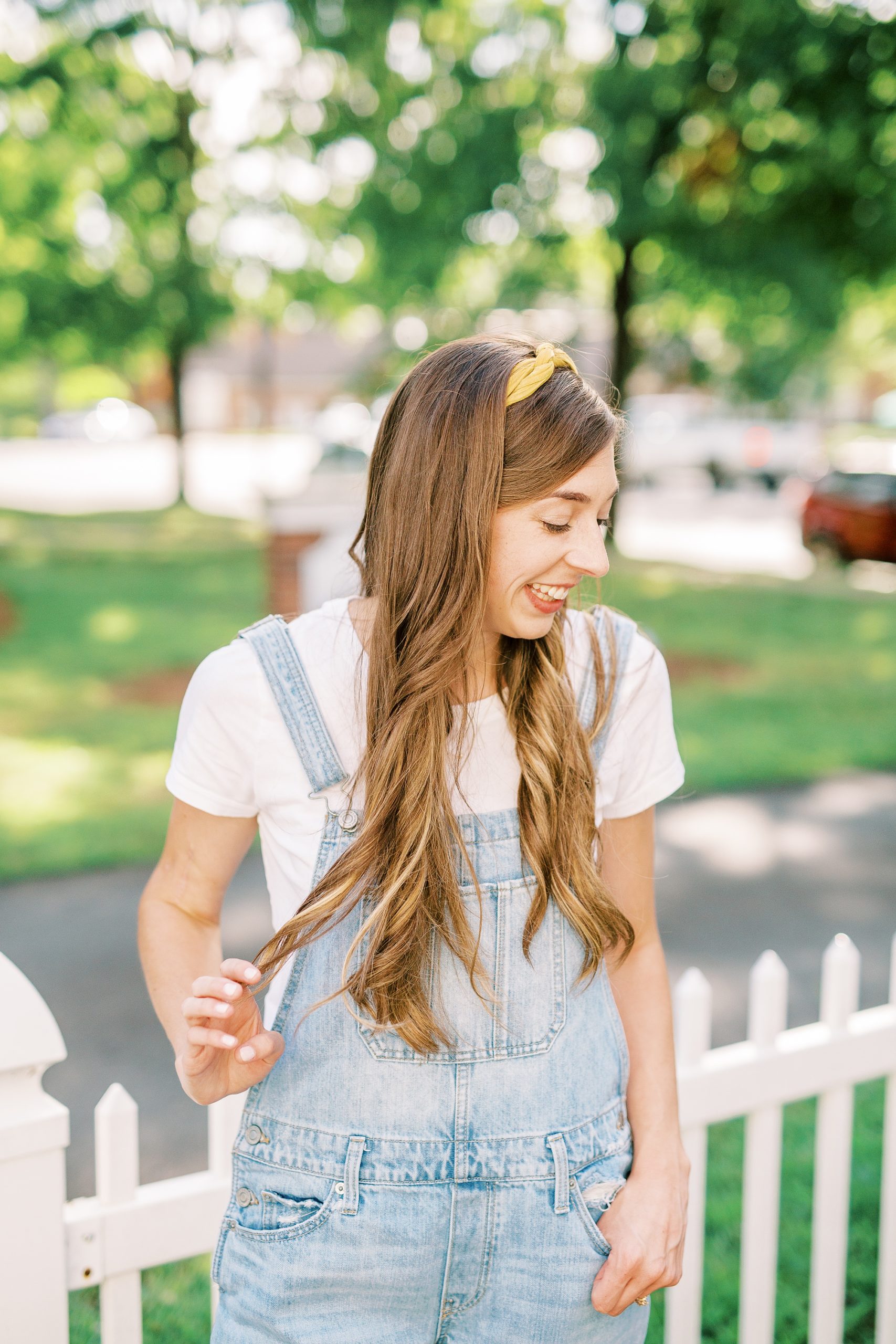 watercolor wedding invitations artist poses in overalls in Charlotte NC garden