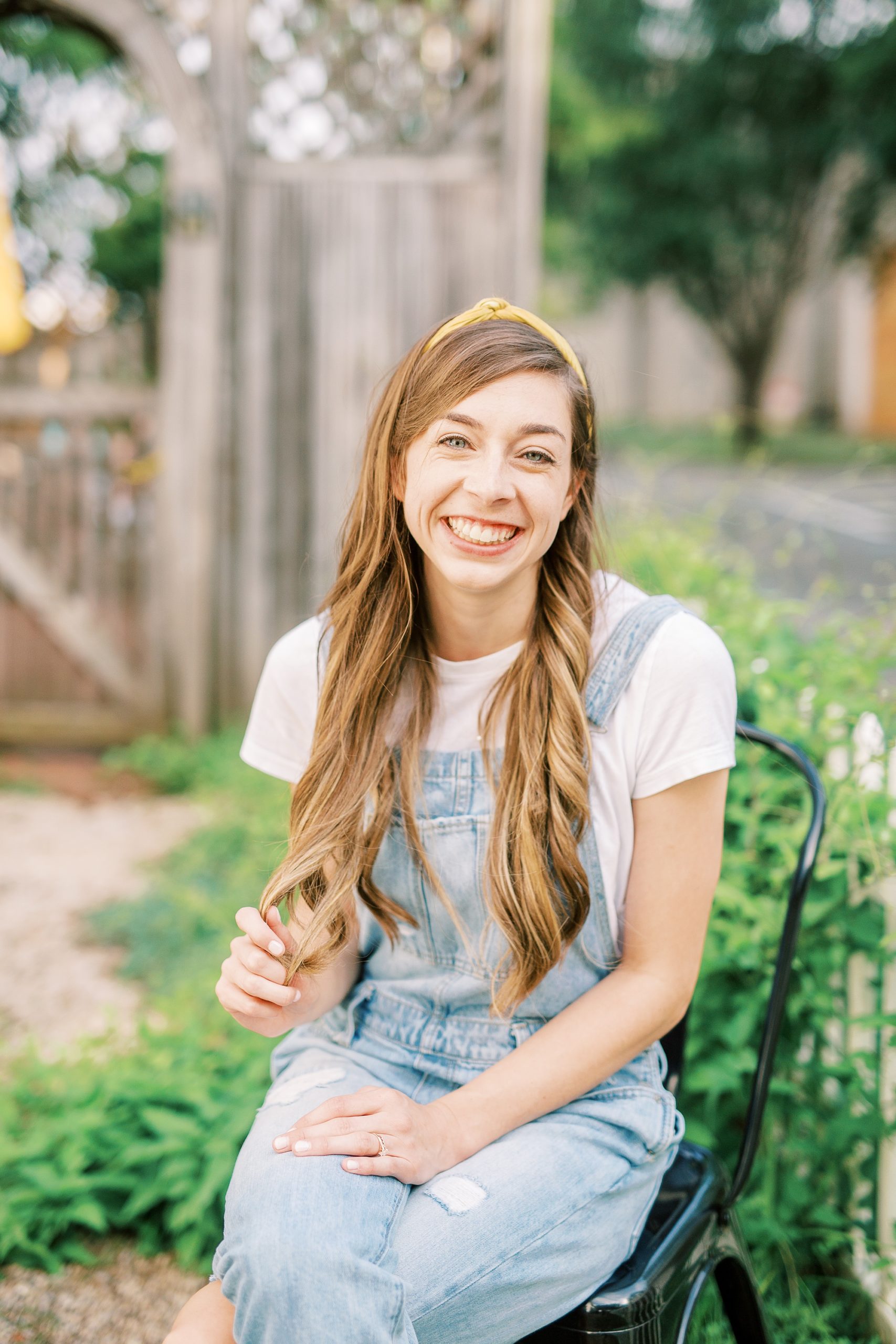 watercolor wedding invitations designer sits on bench outside Charlotte cafe