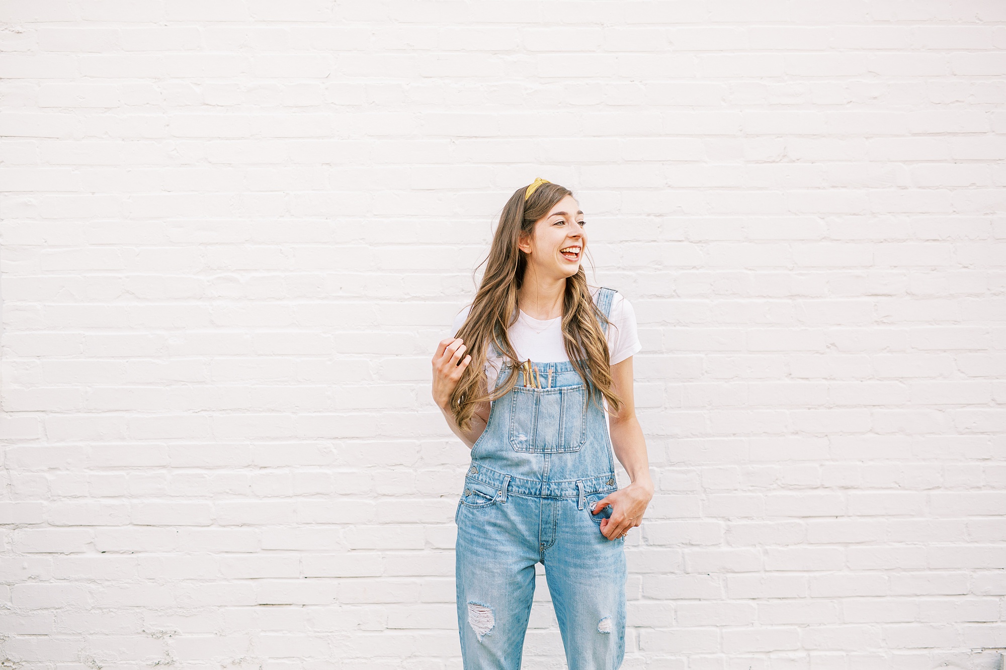 branding portraits for watercolor wedding invitations designer by white wall in Charlotte NC