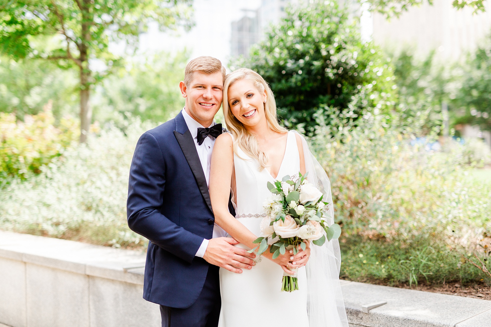 couple poses on sidewalk in Romare Bearden Park