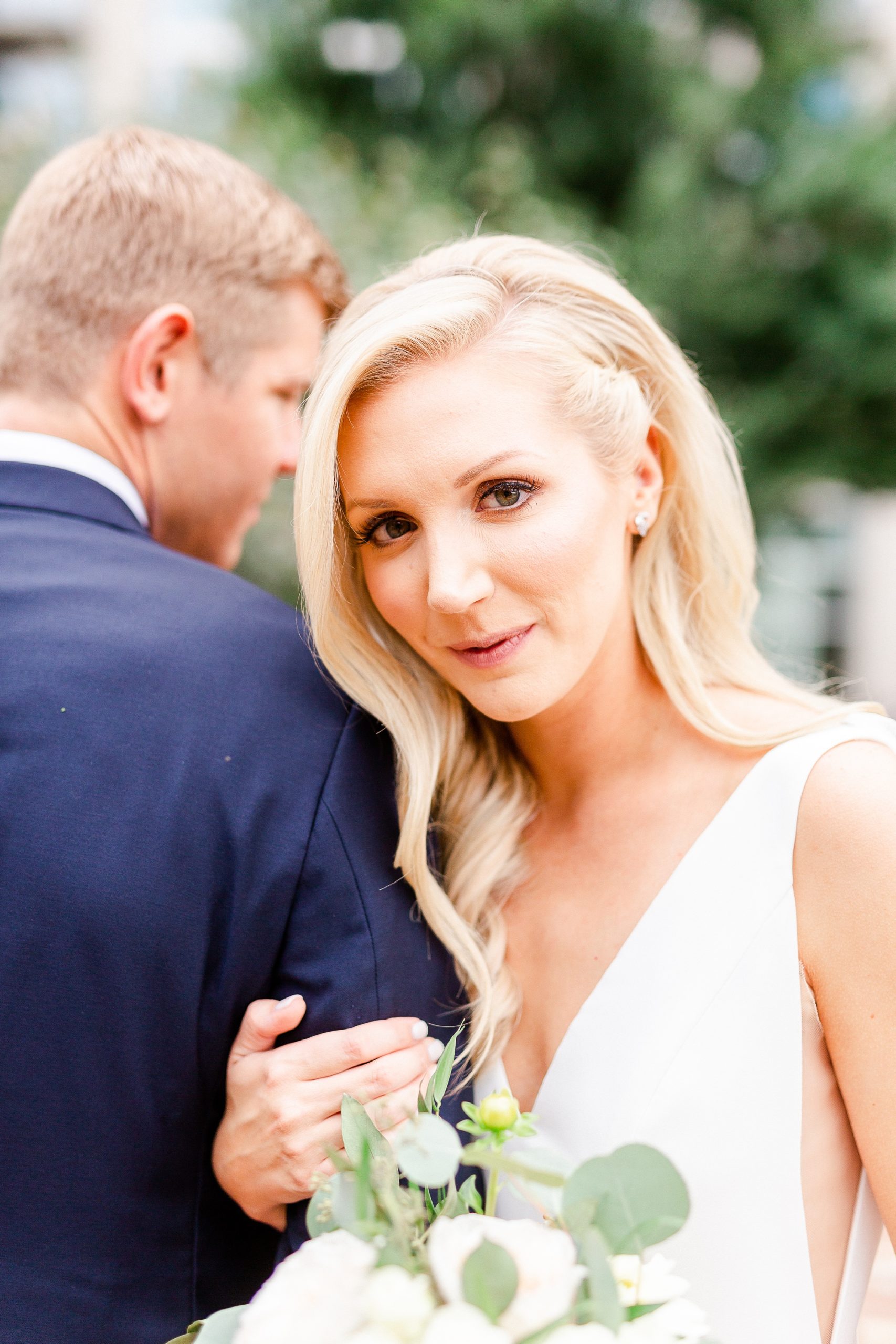 bride leans against groom's shoulder during portraits at Romare Bearden Park