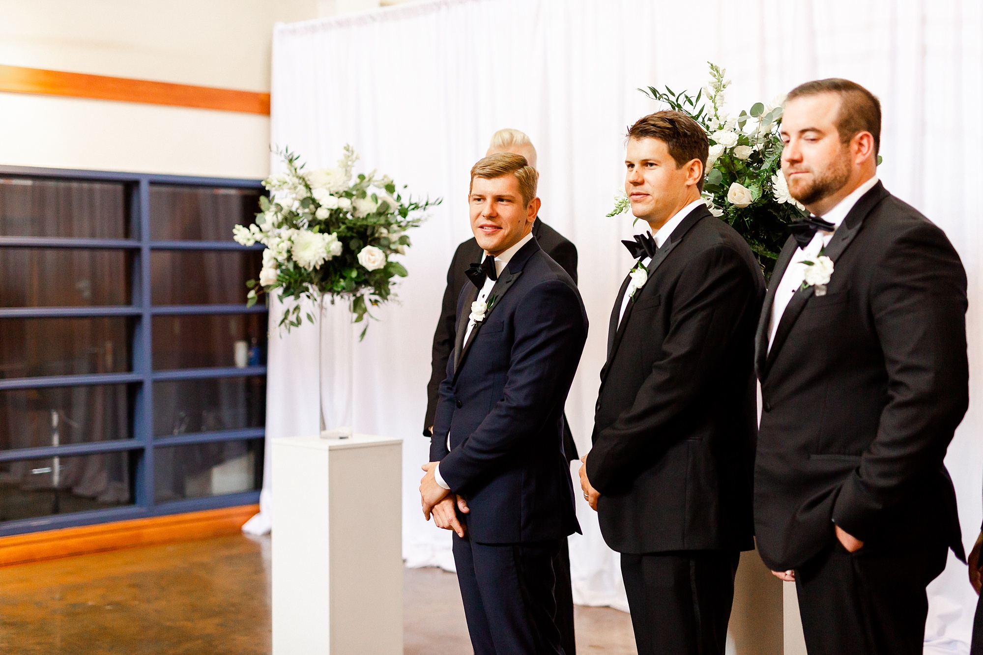groom watches bride walk down the aisle