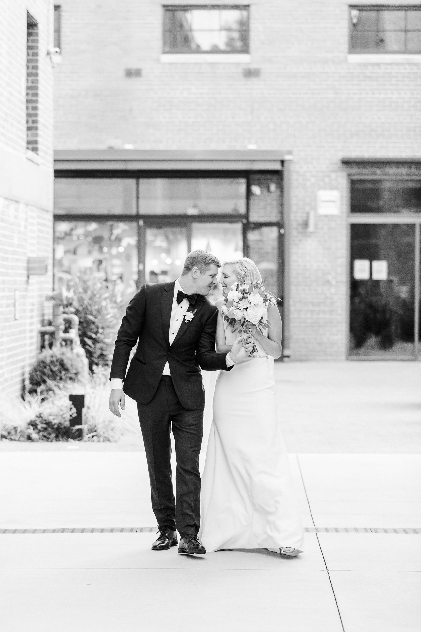 bride and groom laugh with foreheads touching outside Byron's South End