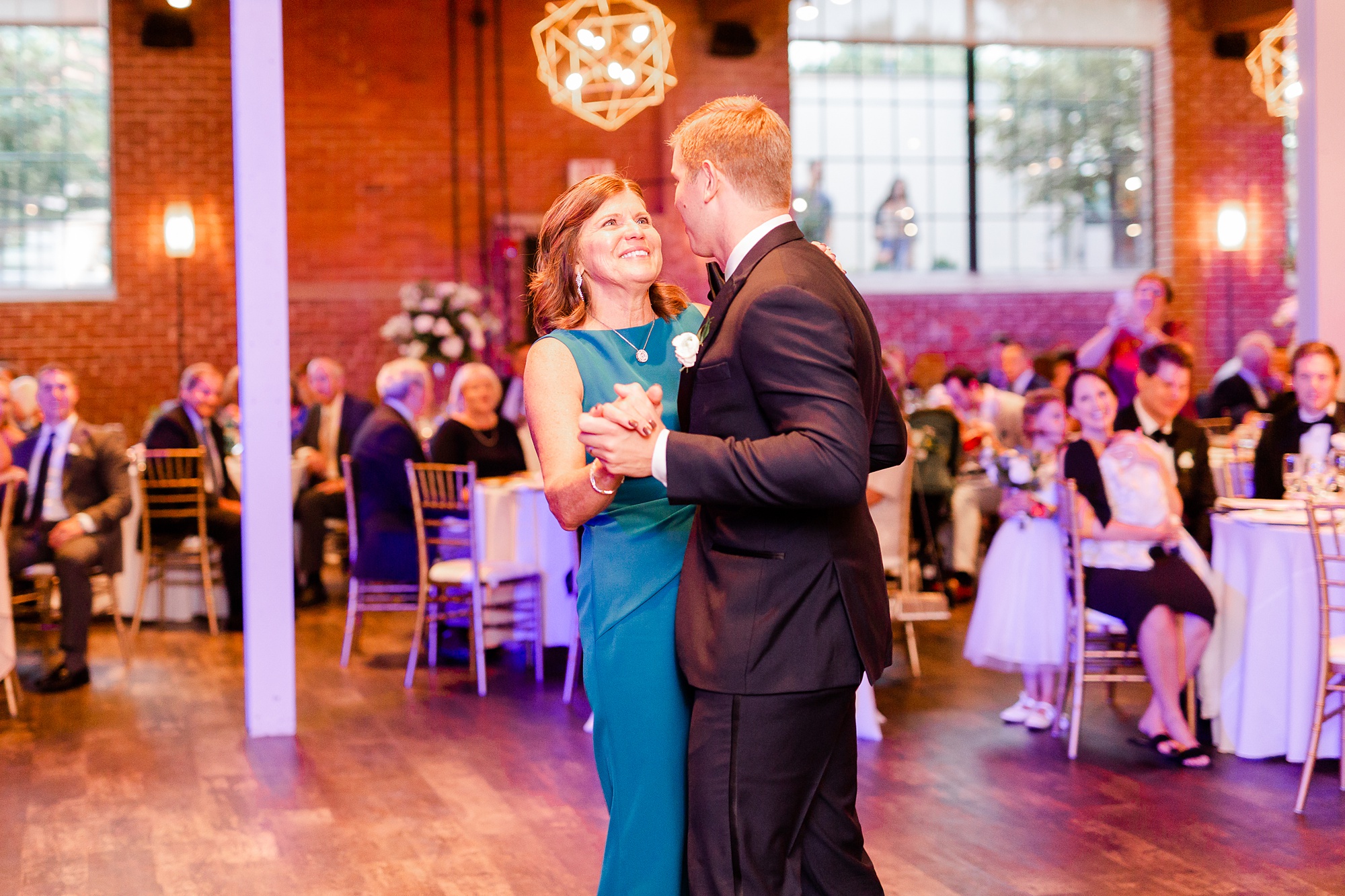 groom dances with mother during Byron's South End wedding reception