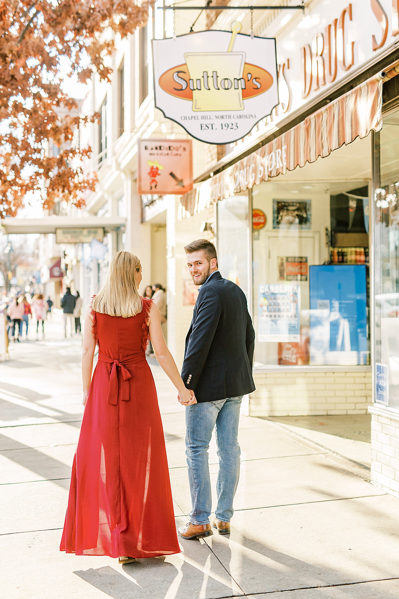 couple holds hands walking downtown Chapel Hill