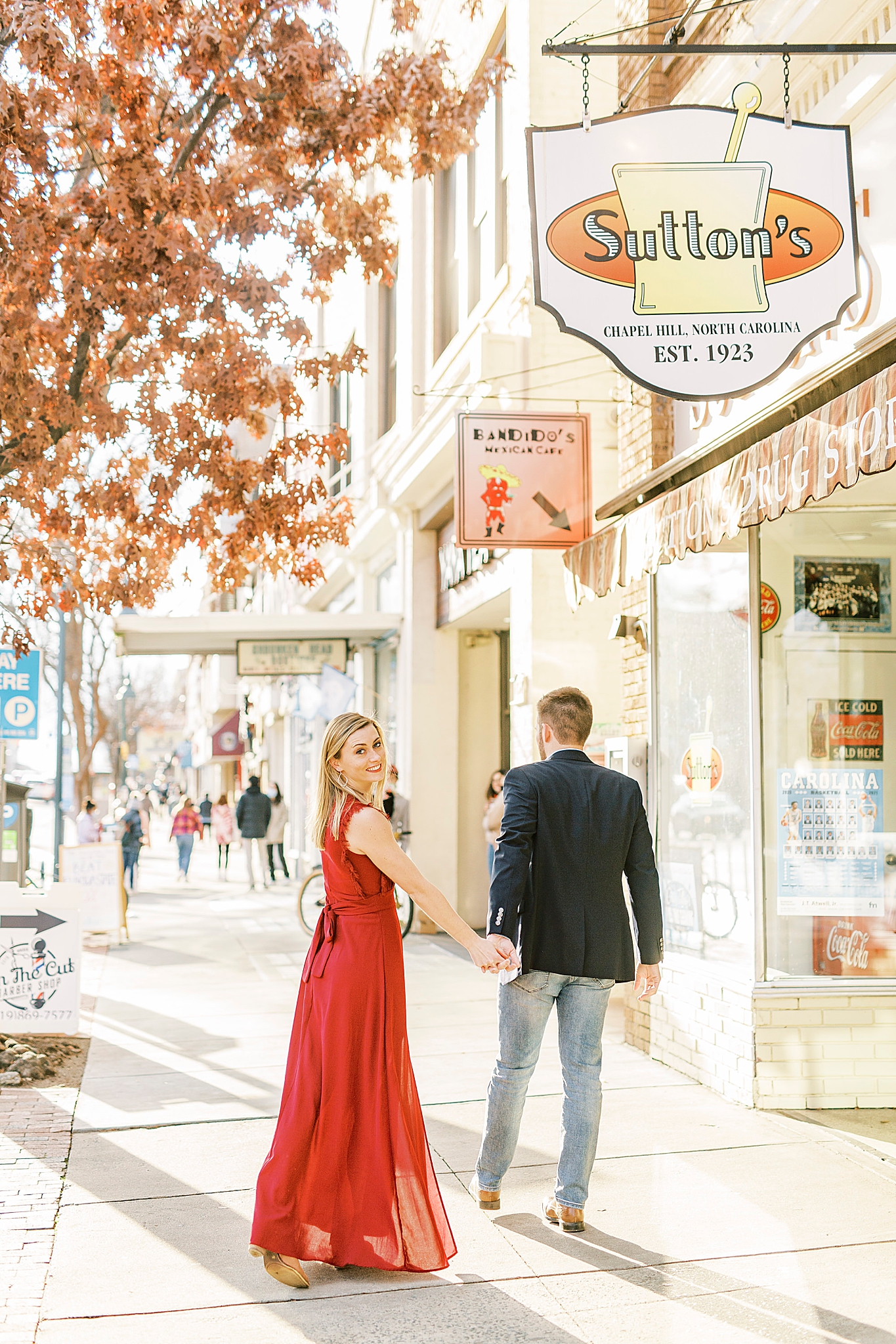 bride and groom walk down street in downtown Chapel Hill