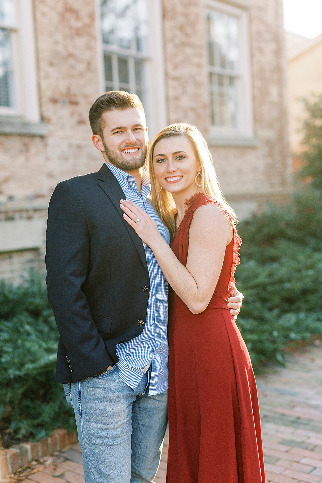 bride cuddles with groom during winter engagement photos