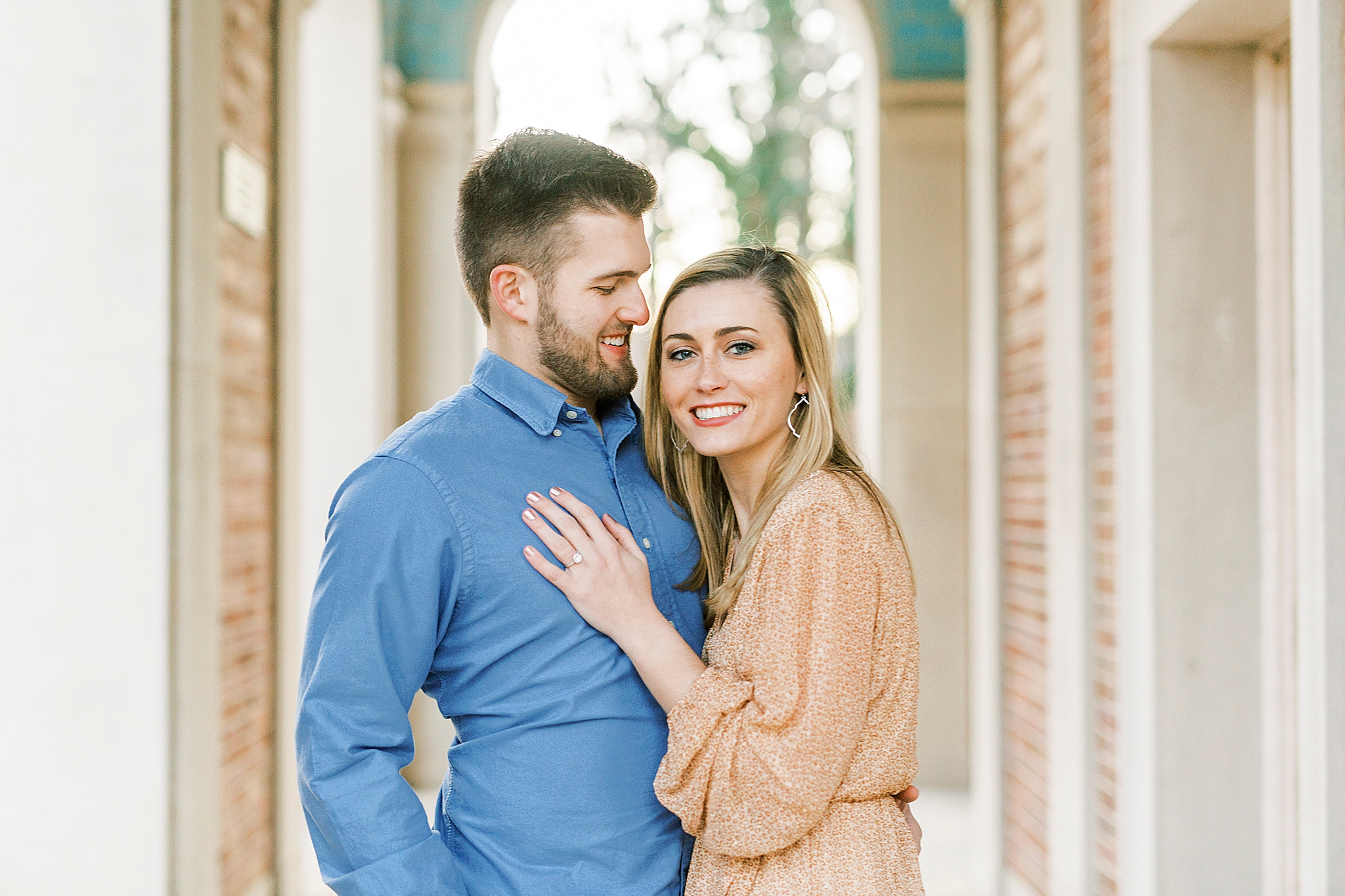 engaged couple poses in bell tower at UNC Chapel Hill