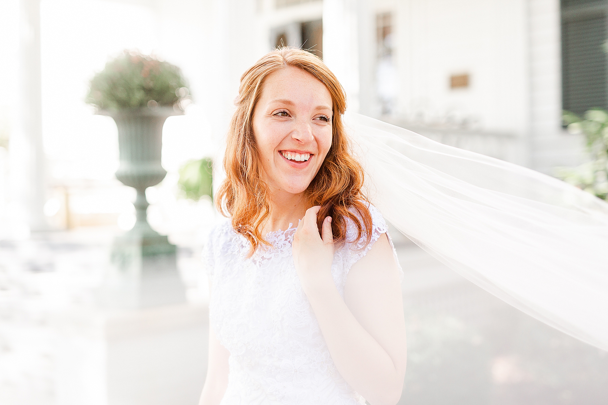 bride laughs with veil floating around her