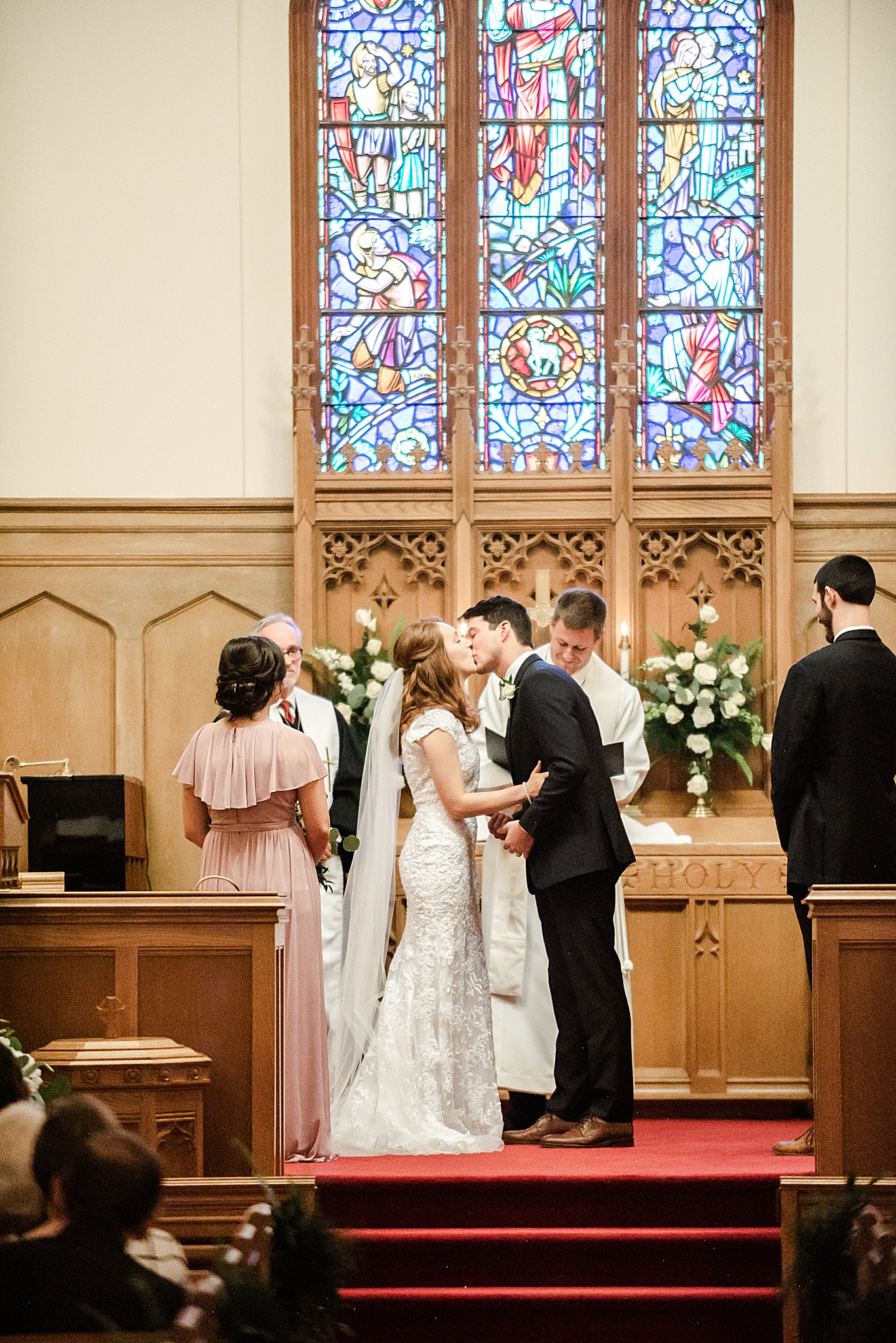 newlyweds kiss during traditional classic Southern wedding ceremony in local church