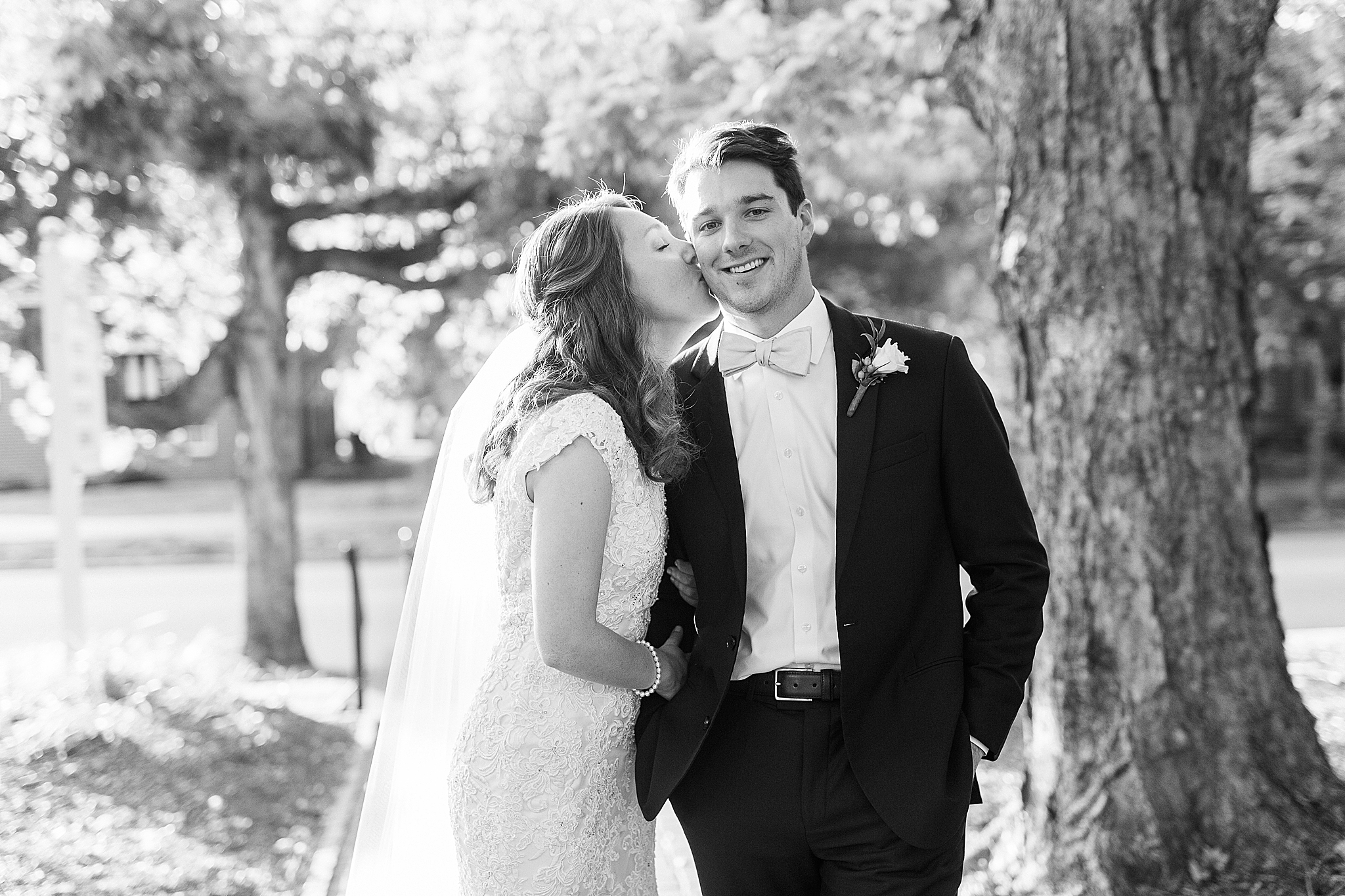 bride kisses groom's cheek during NC wedding photos