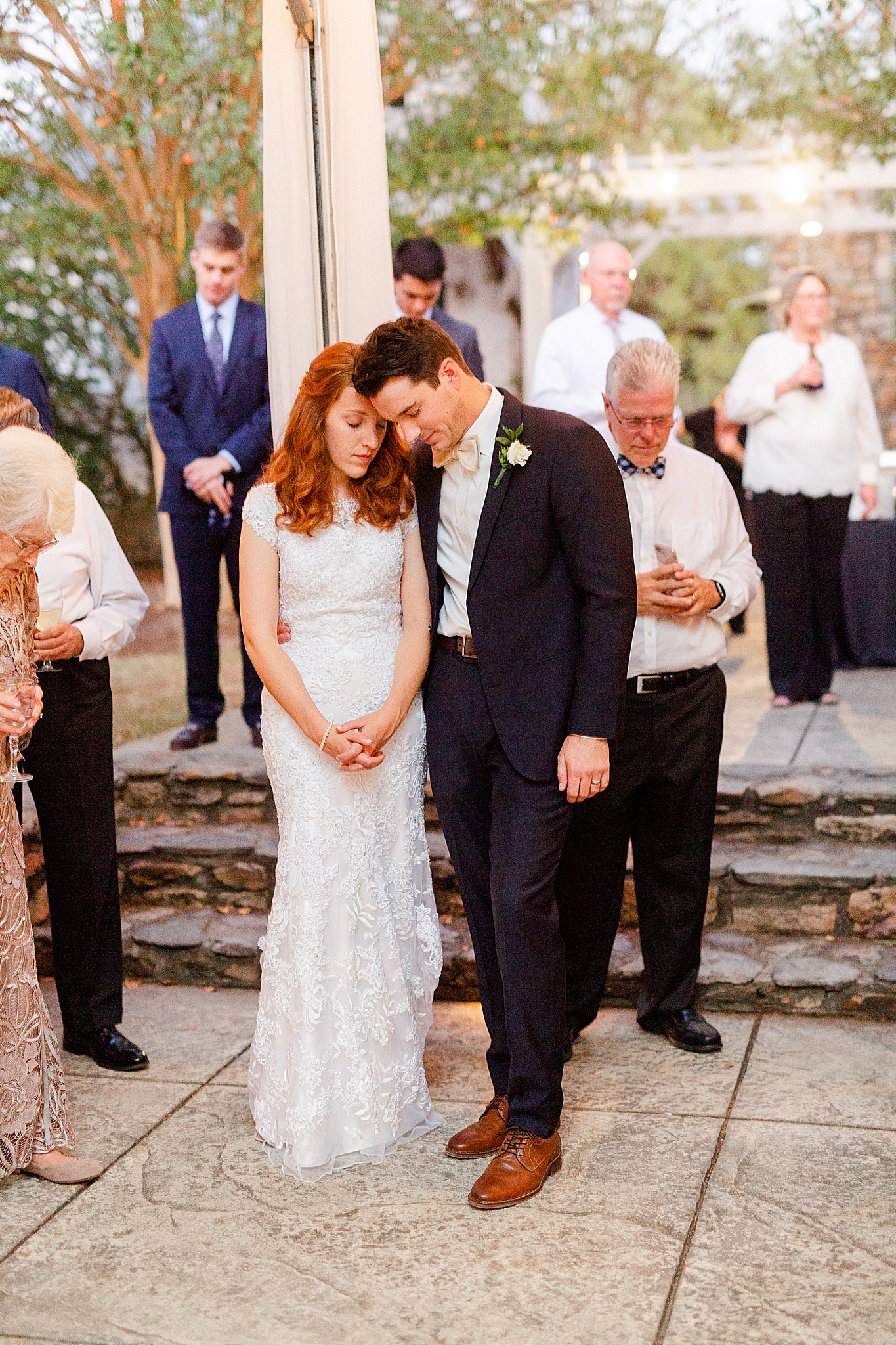 newlyweds pray together during Lake O' The Woods Plantation wedding reception