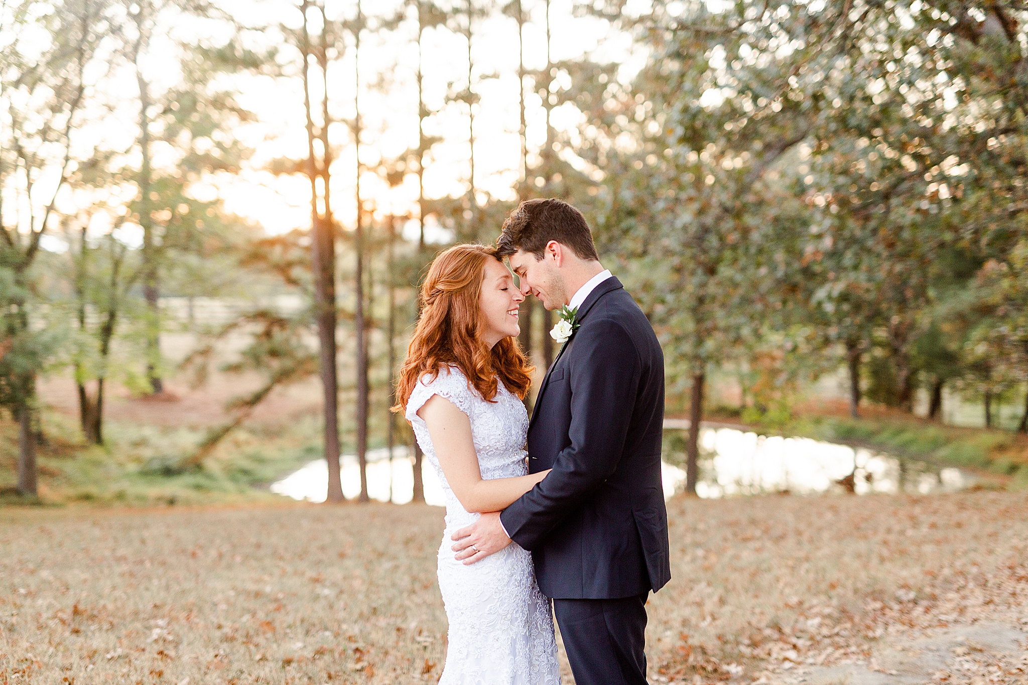 bride and groom stand nose to nose during wedding photos