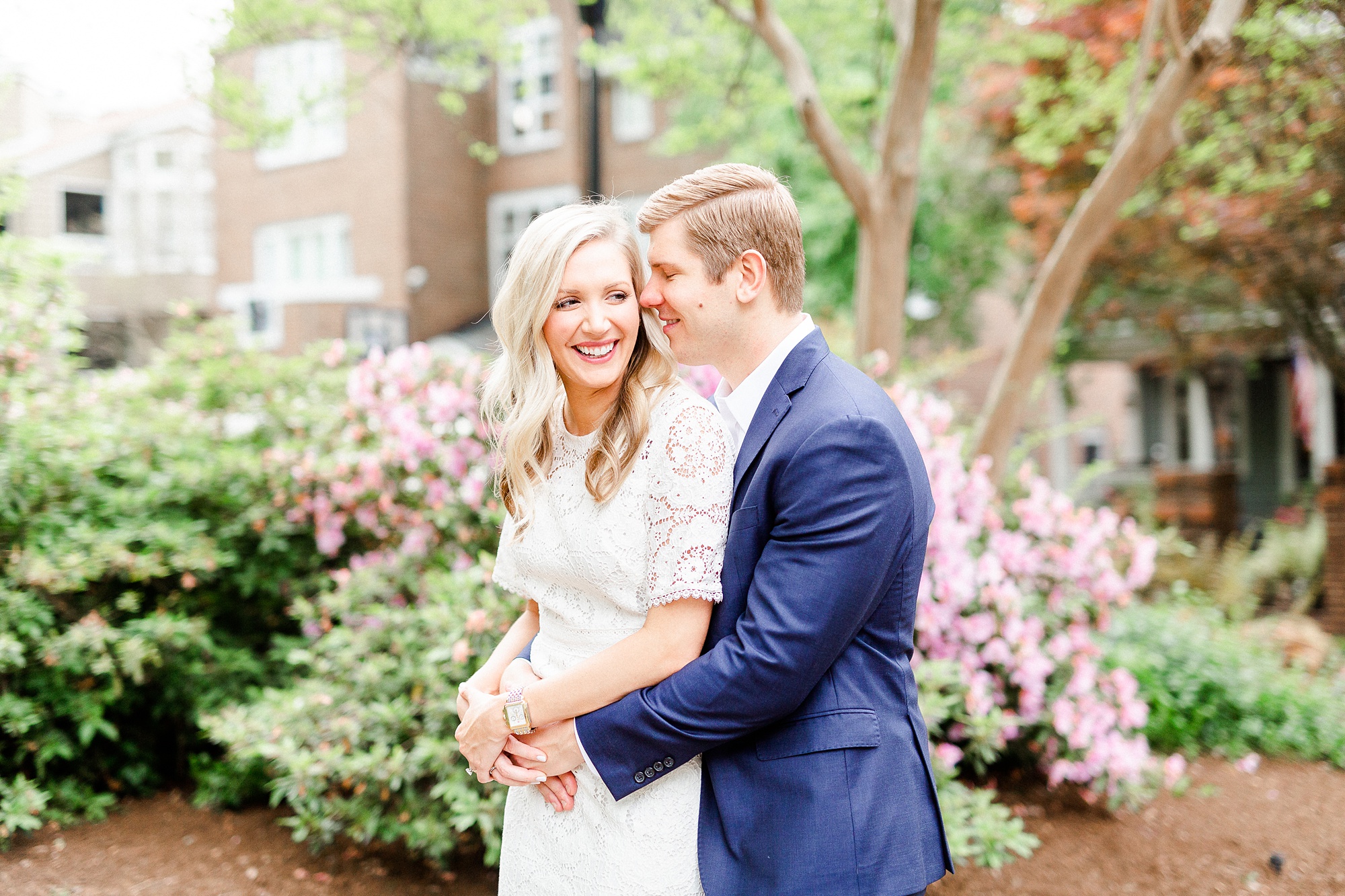 groom hugs bride from behind during engagement photos