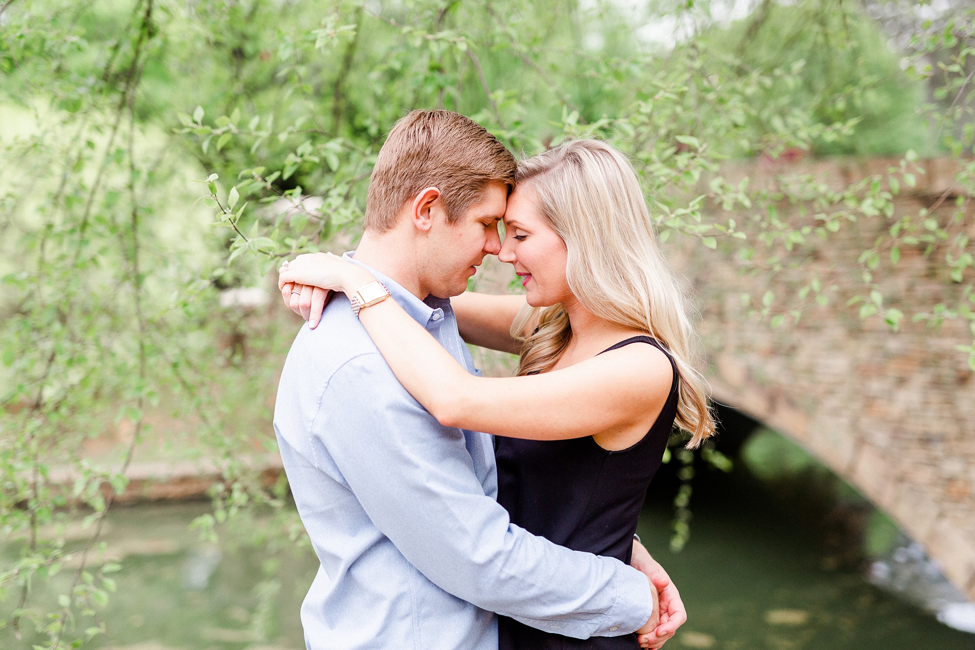 engaged couple stand with heads touching photographed by Kevyn Dixon Photography
