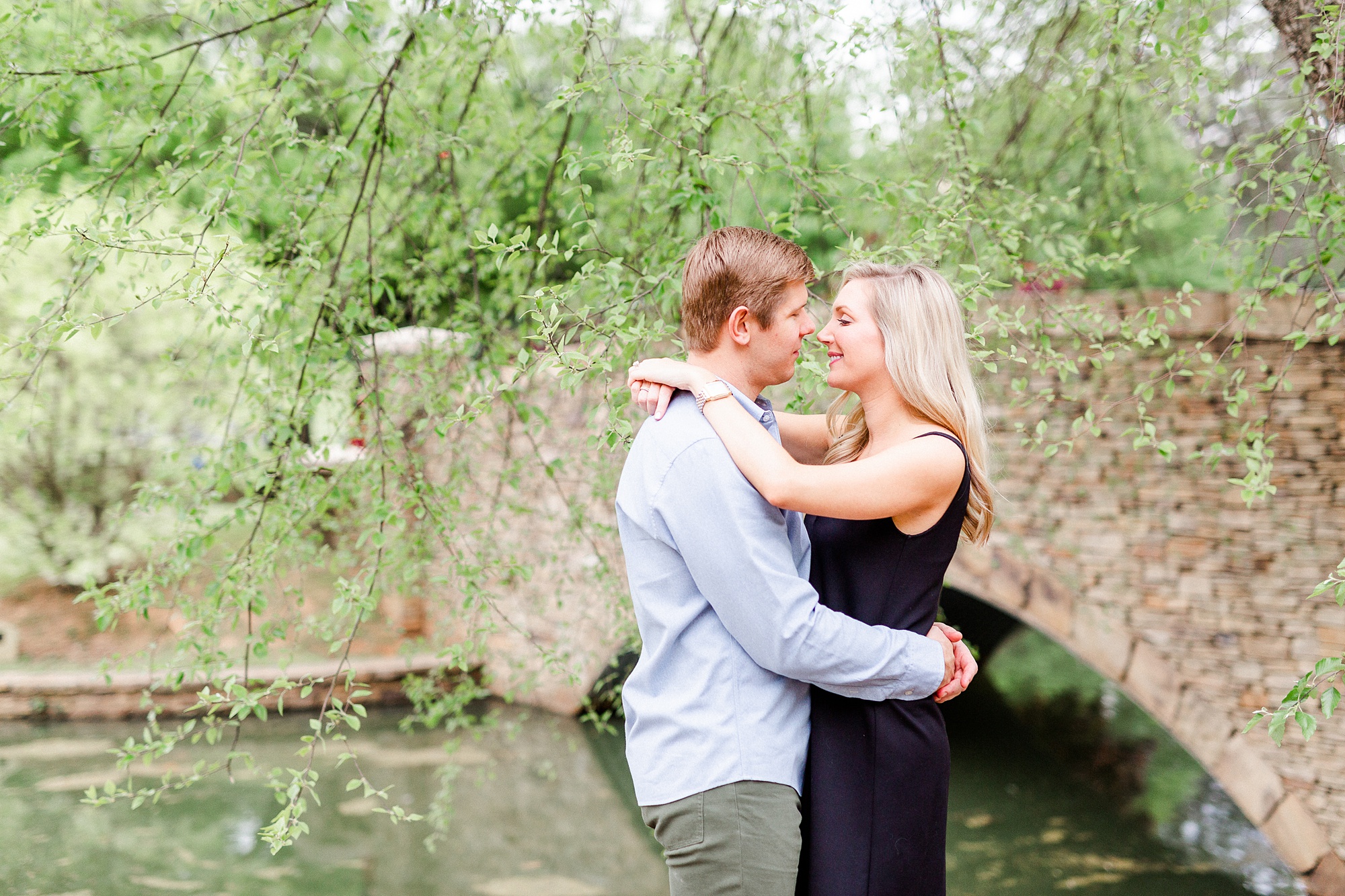 bride and groom pose by bridge in Freedom Park
