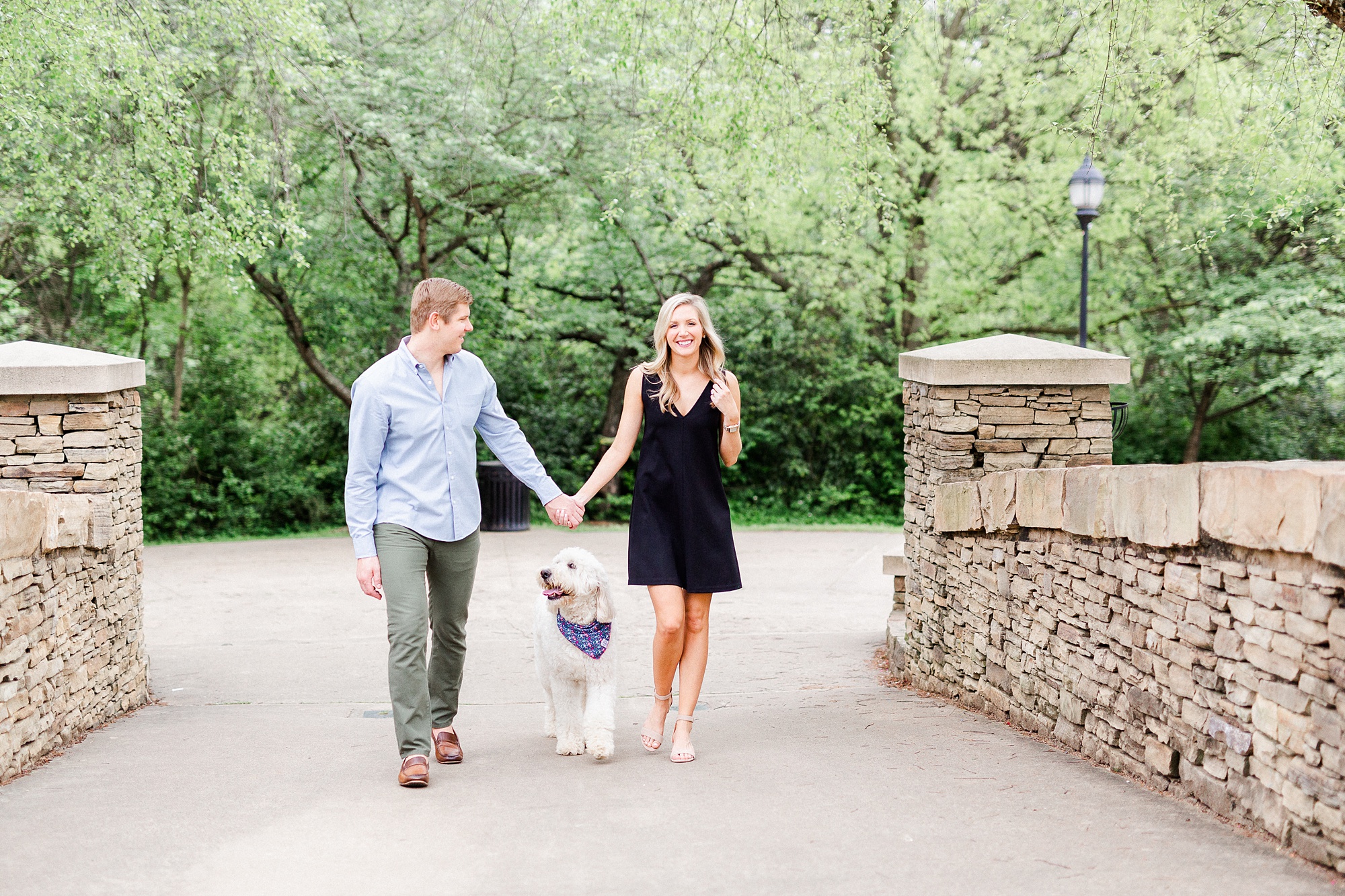 couple walks over bridge at Freedom Park with dog
