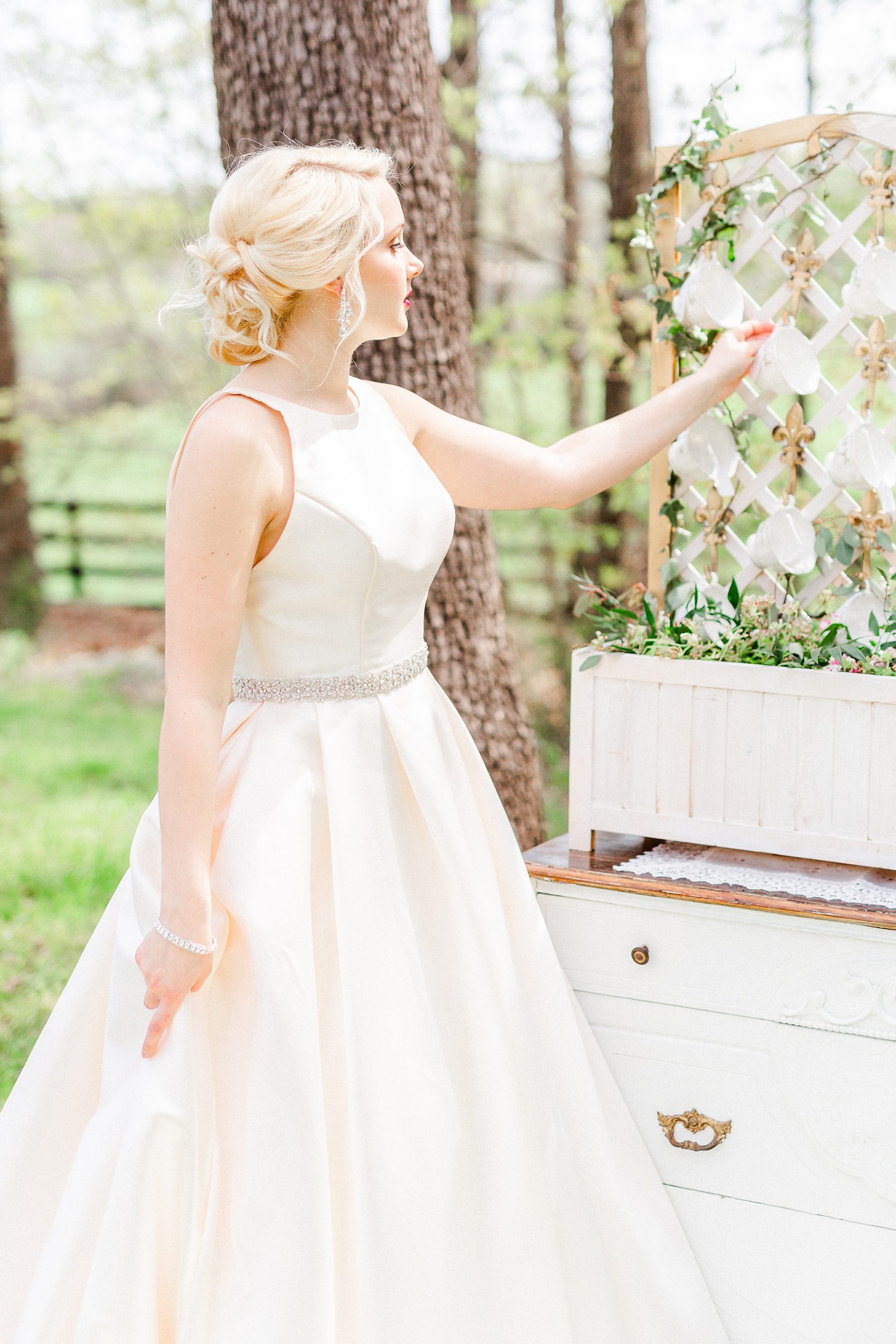 bride looks at teacup seating chart display
