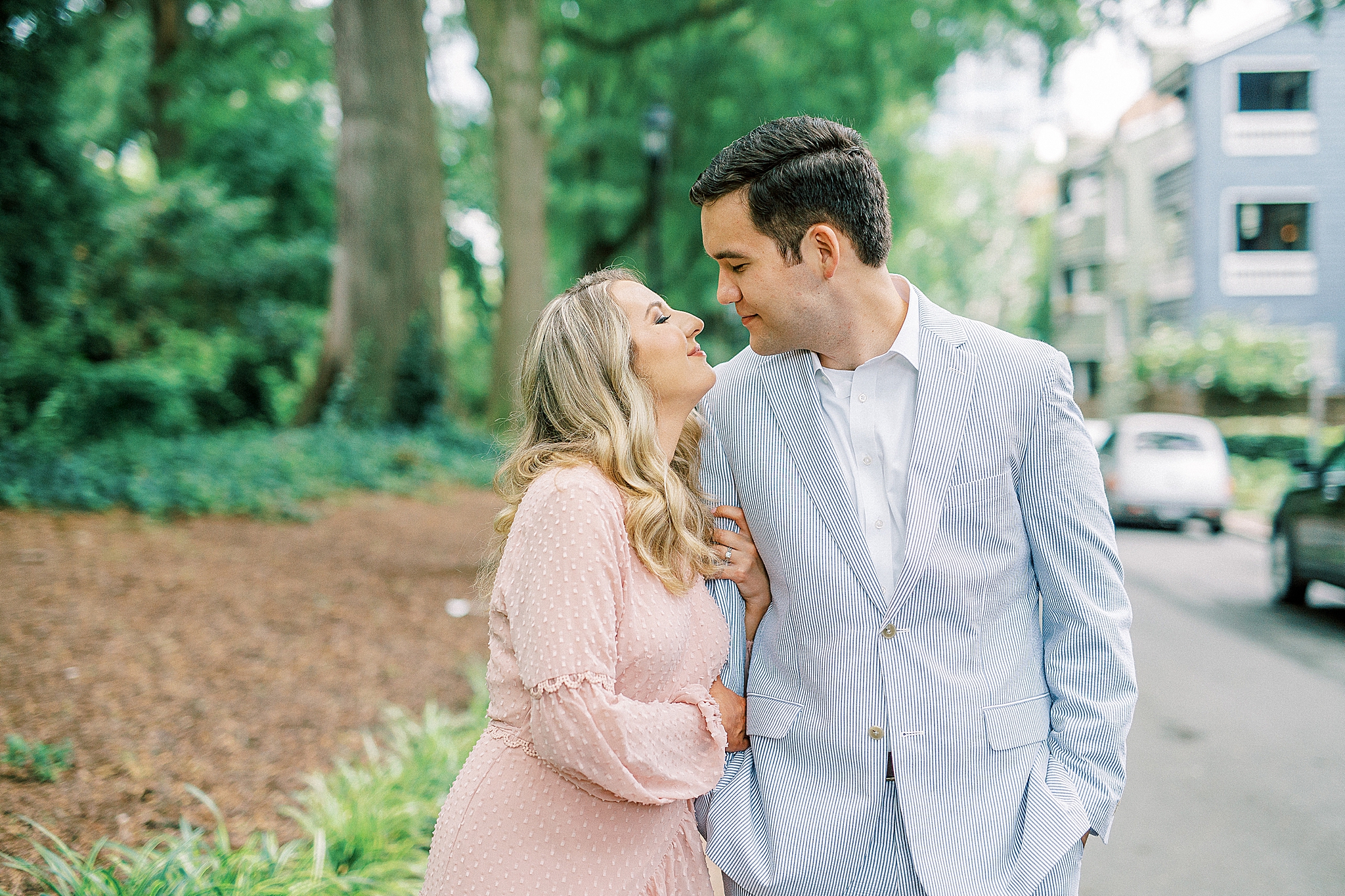 engaged couple leans in for a kiss at Fourth Ward Park