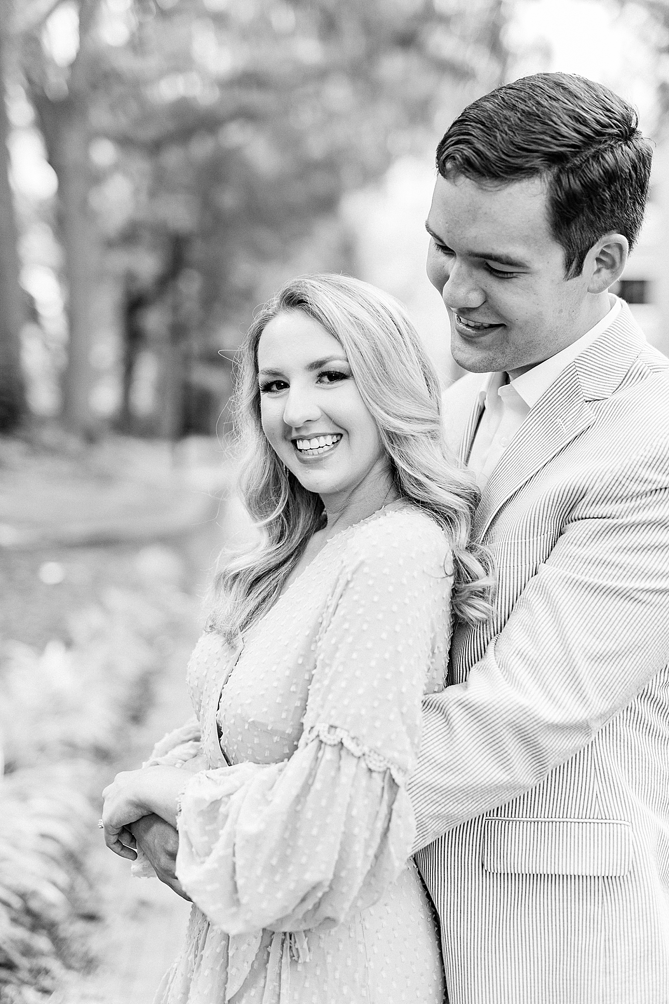 groom hugs bride from behind during Fourth Ward Park engagement photos