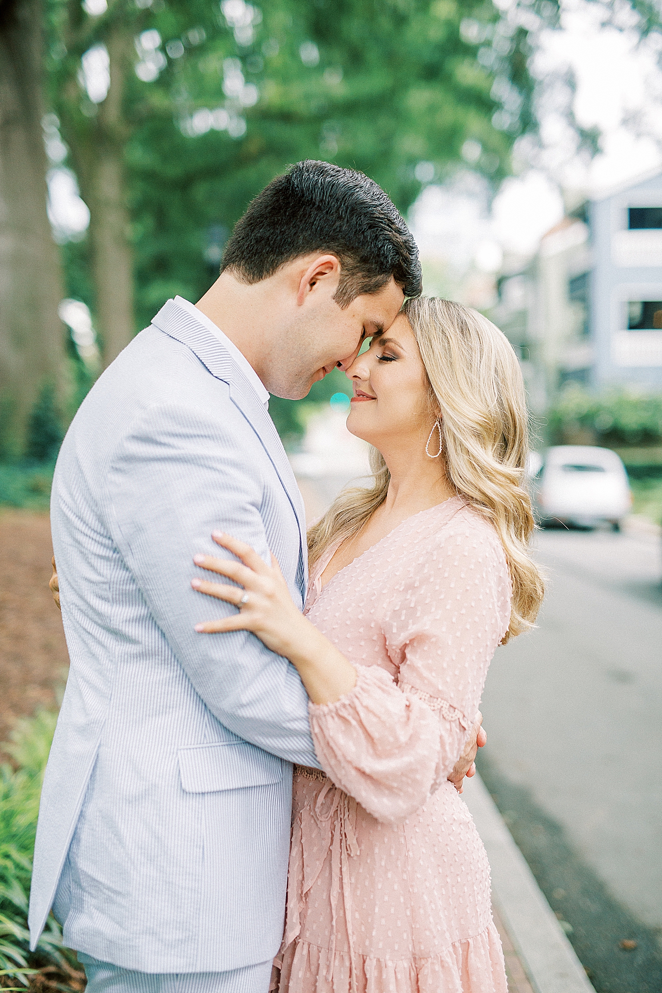 engaged couple poses on sidewalk in Fourth Ward Park