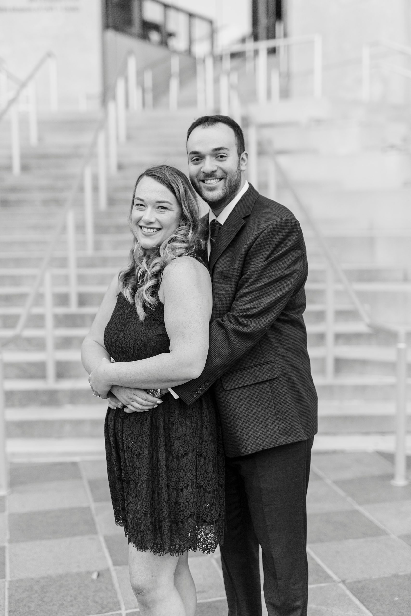 groom hugs bride during Mint Museum engagement session