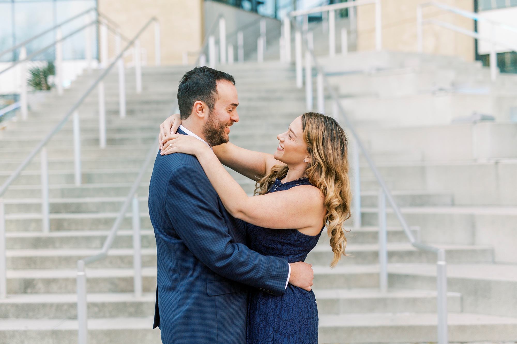 engaged couple hugs on steps of Mint Museum