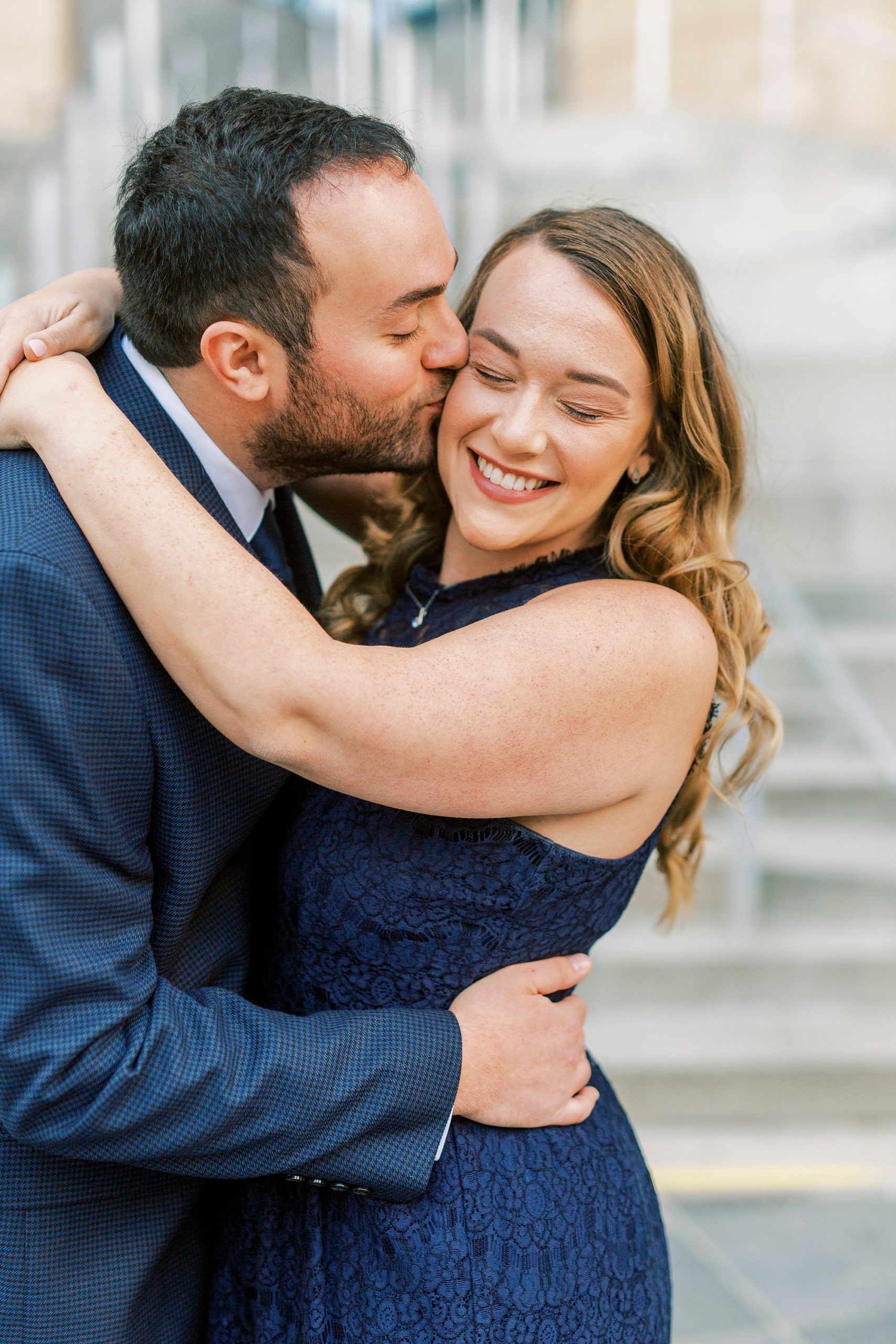 groom kisses bride during Mint Museum engagement session