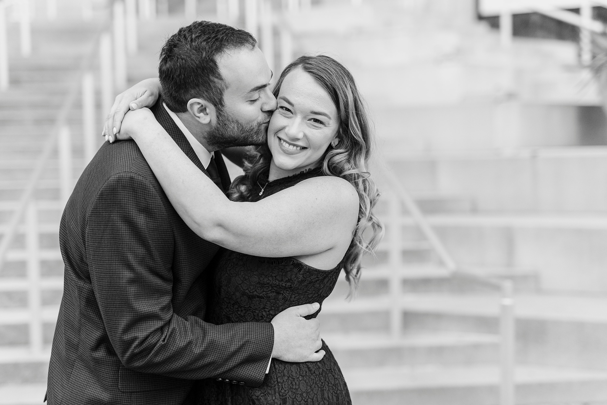 groom kisses bride's cheek during Mint Museum engagement photos