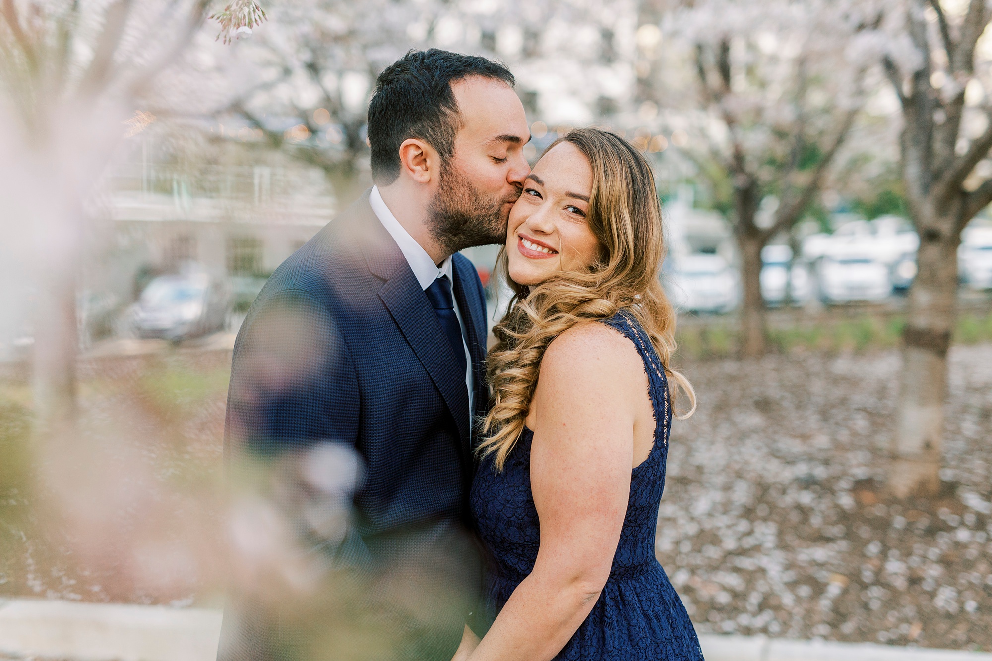 groom kisses bride's forehead during Uptown Charlotte engagement photos