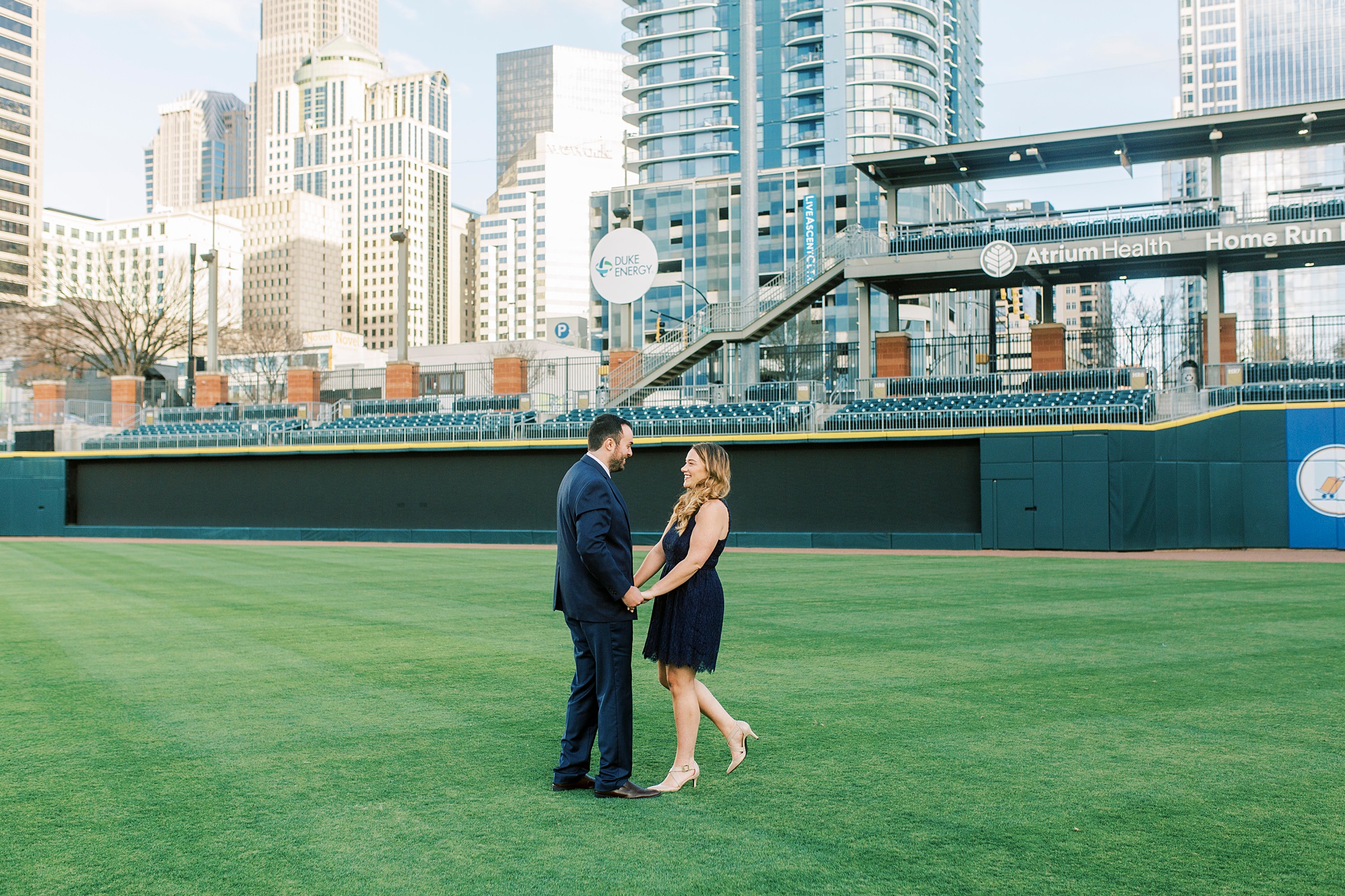 engaged couple walks on field at Truist Field