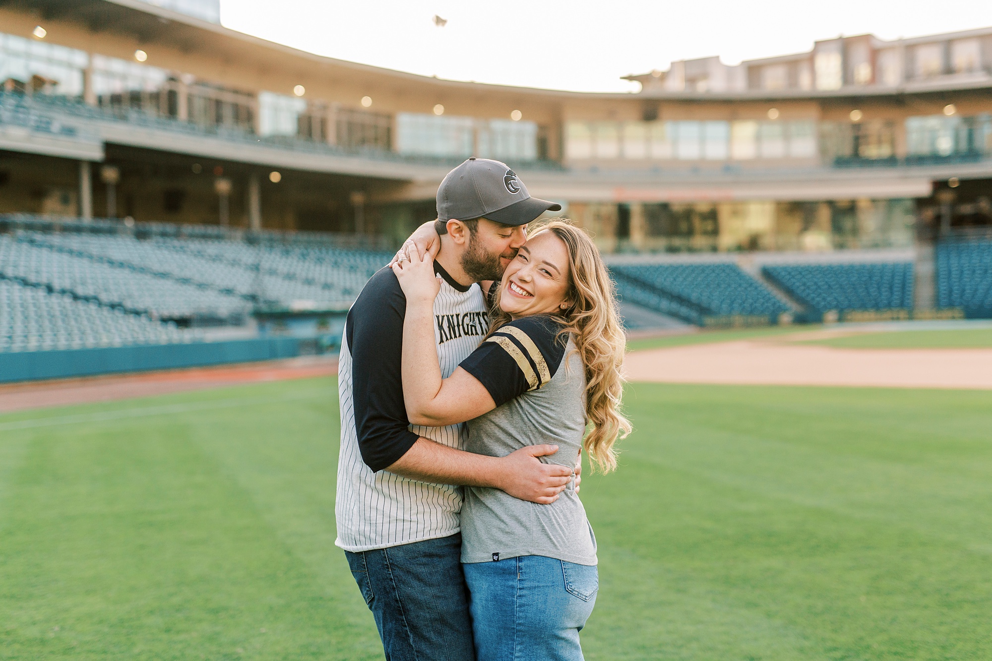 groom leans down to kiss bride inside Truist Field