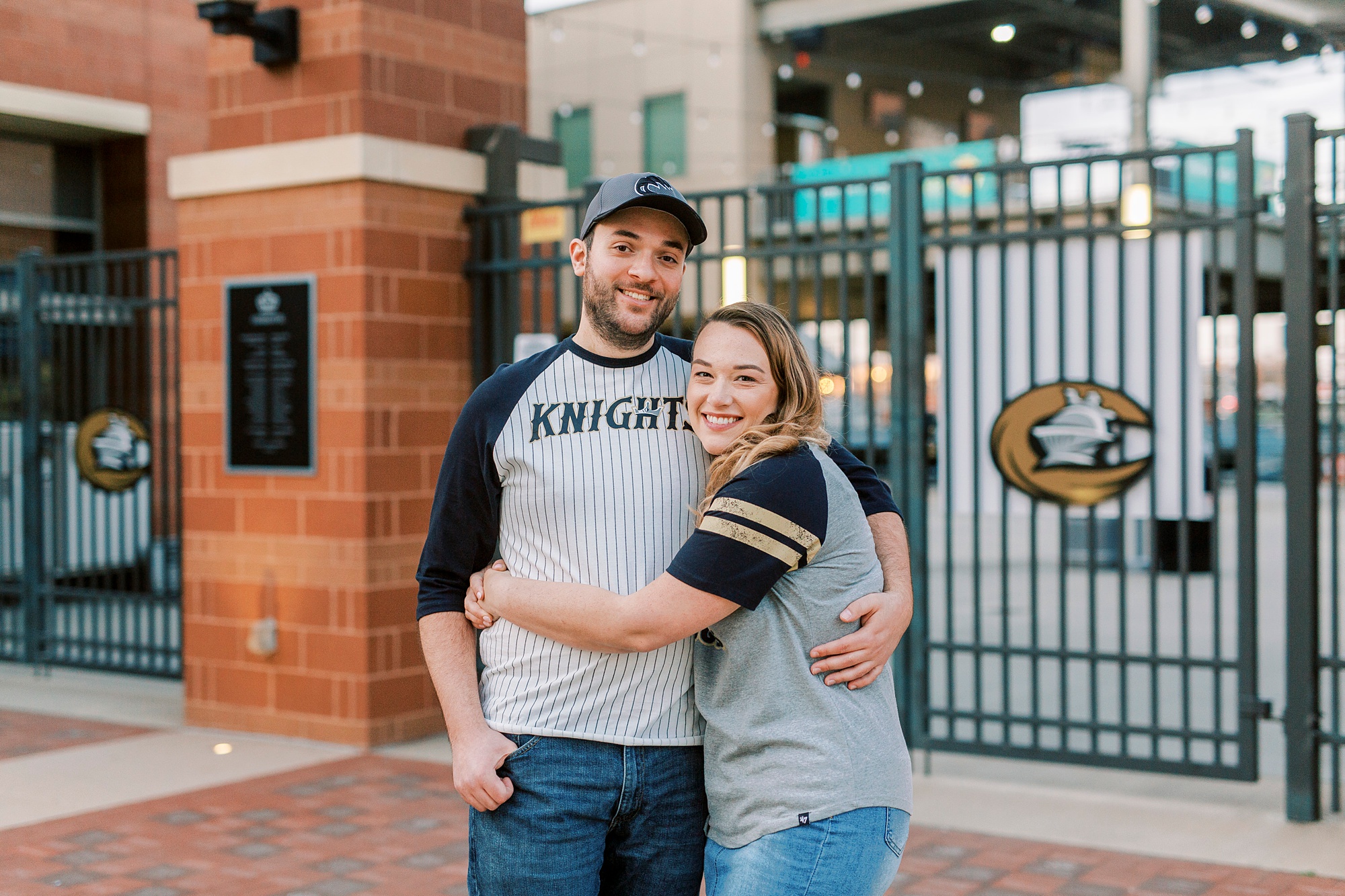engaged couple hugs outside Truist Field in Charlotte NC